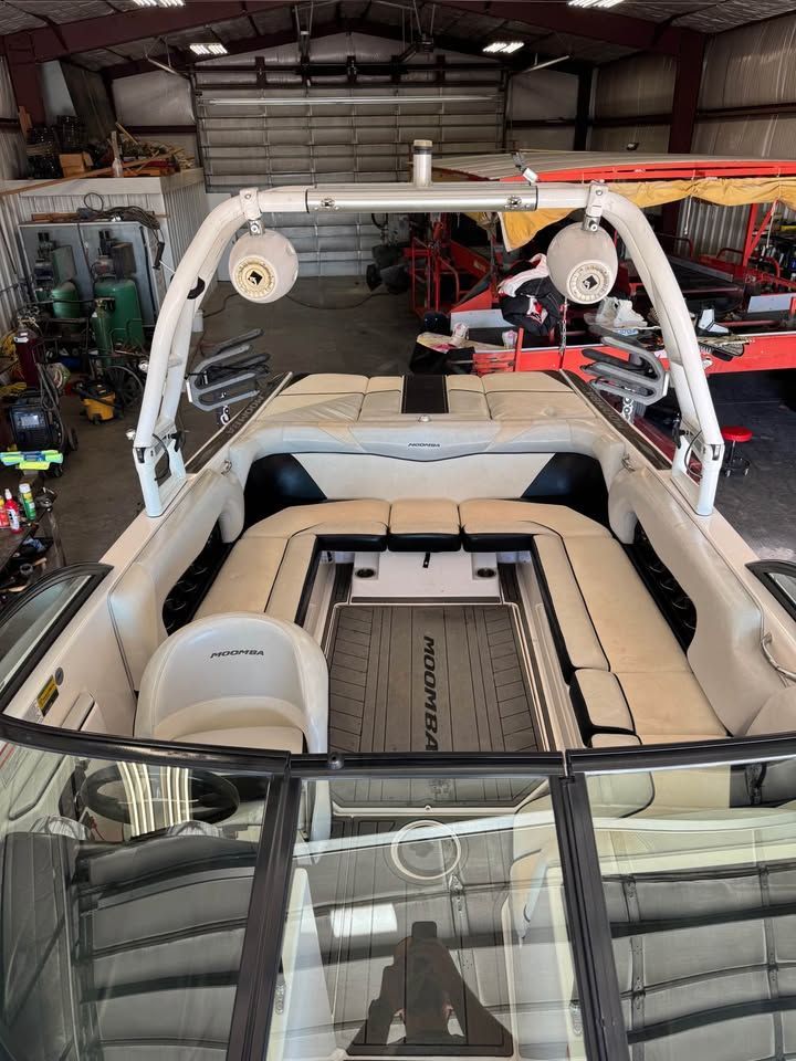 Interior view of a 2015 Moomba Mojo with white seating and a tower in a storage facility.
