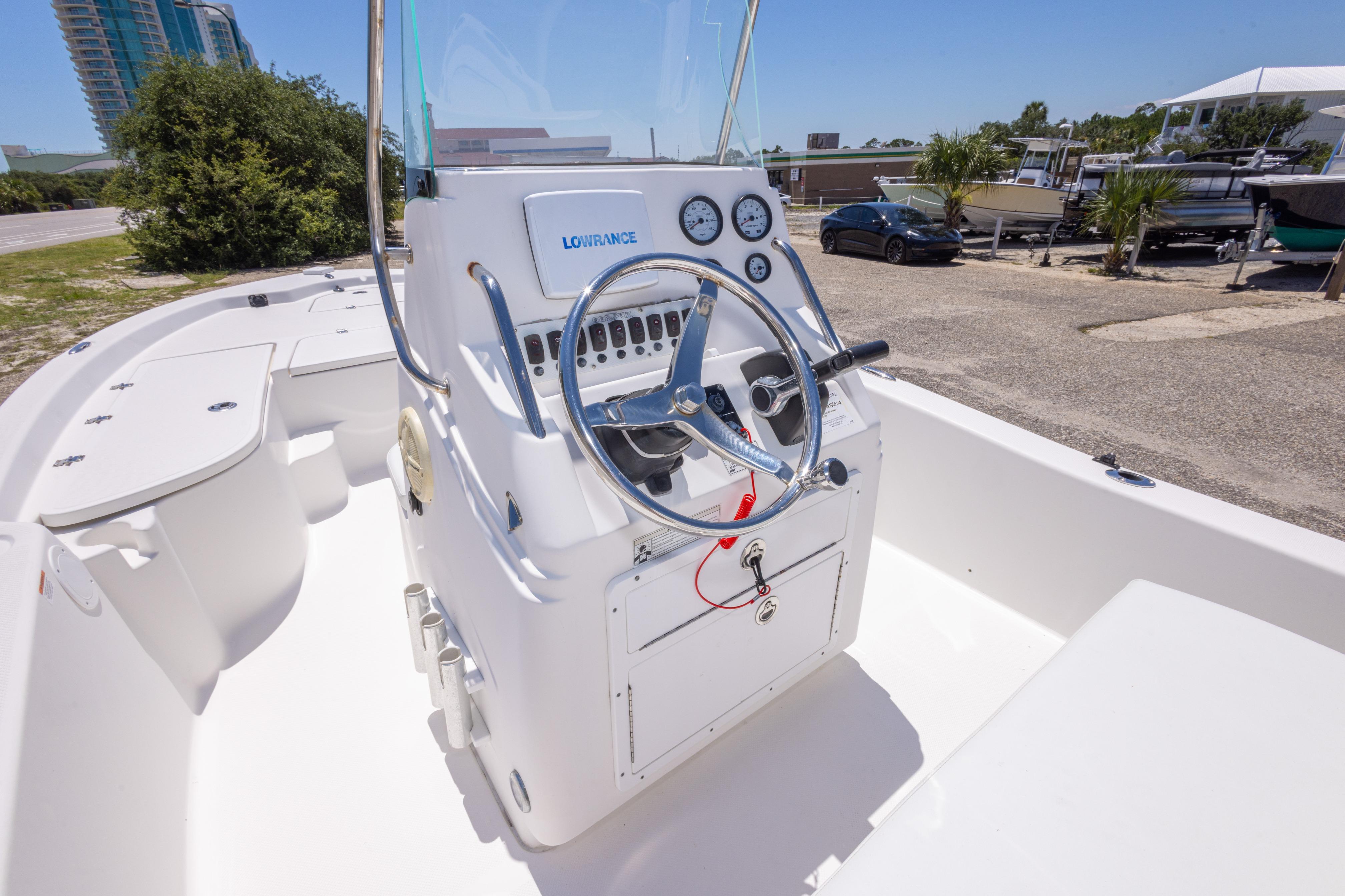 2011 Sea Fox 200XT boat cockpit with steering wheel and control panel, parked outdoors.
