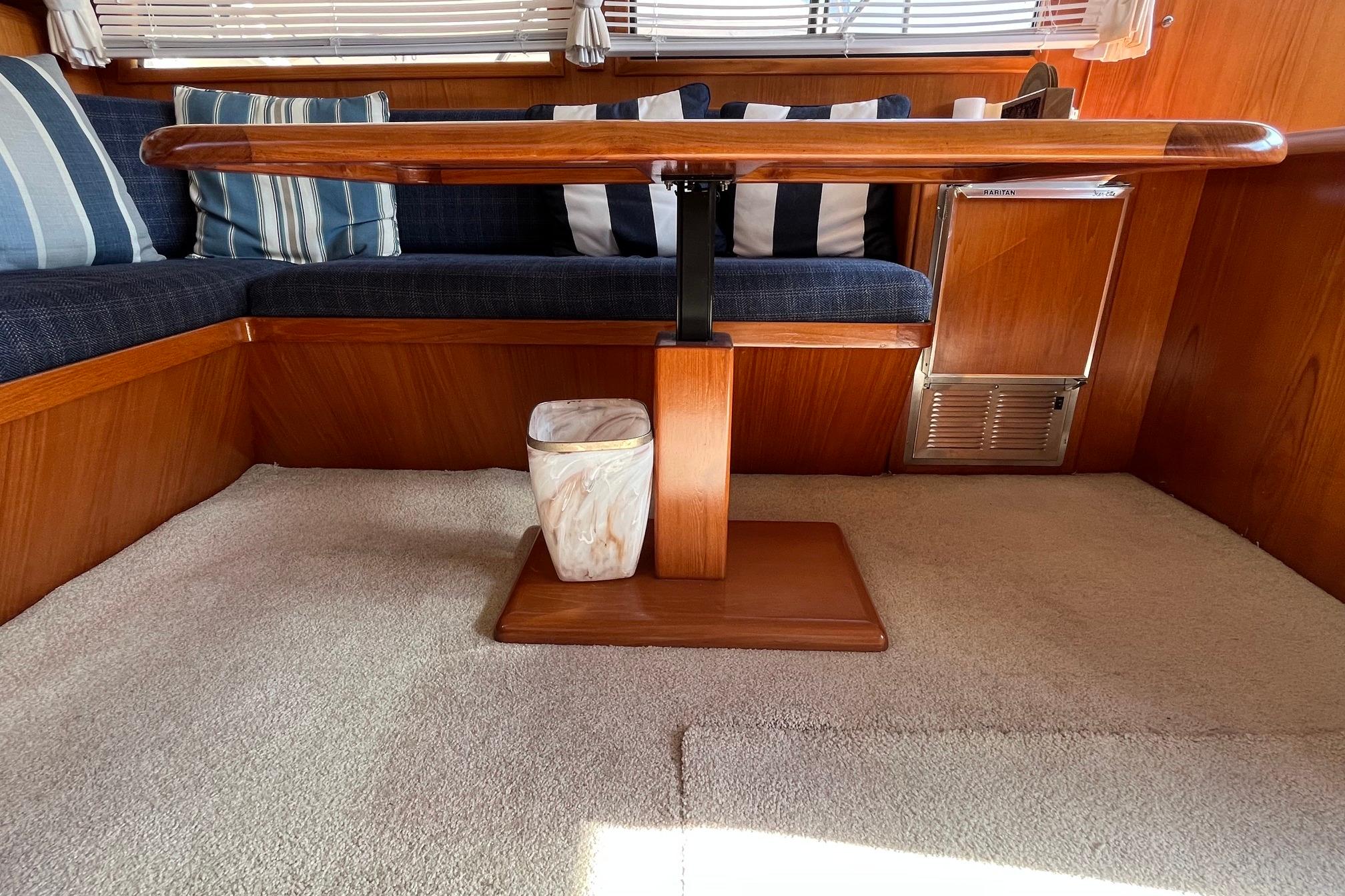 Interior of 1989 Ocean Alexander 440 Sundeck CPMY with wooden table and striped cushions.