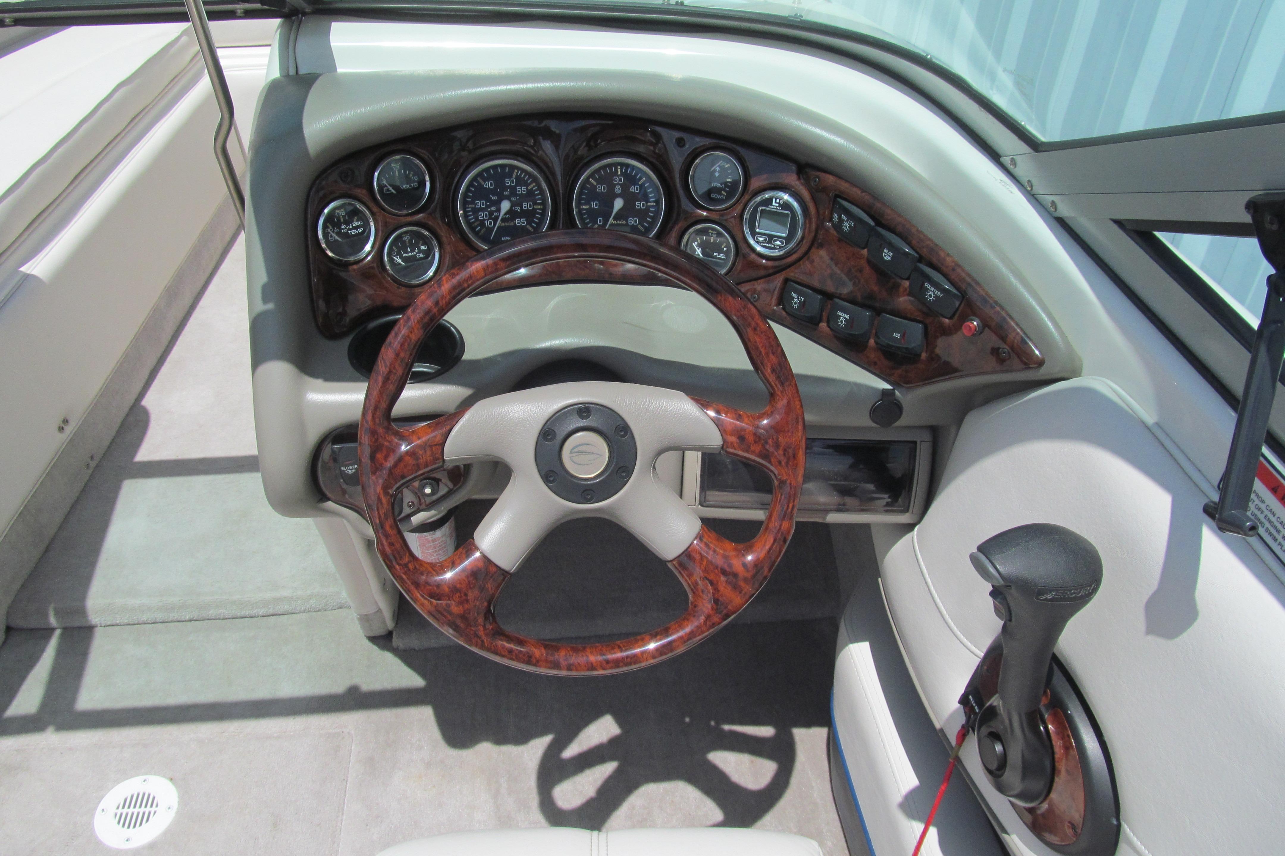 Steering wheel and dashboard of a 2001 Crownline 225 BR boat.
