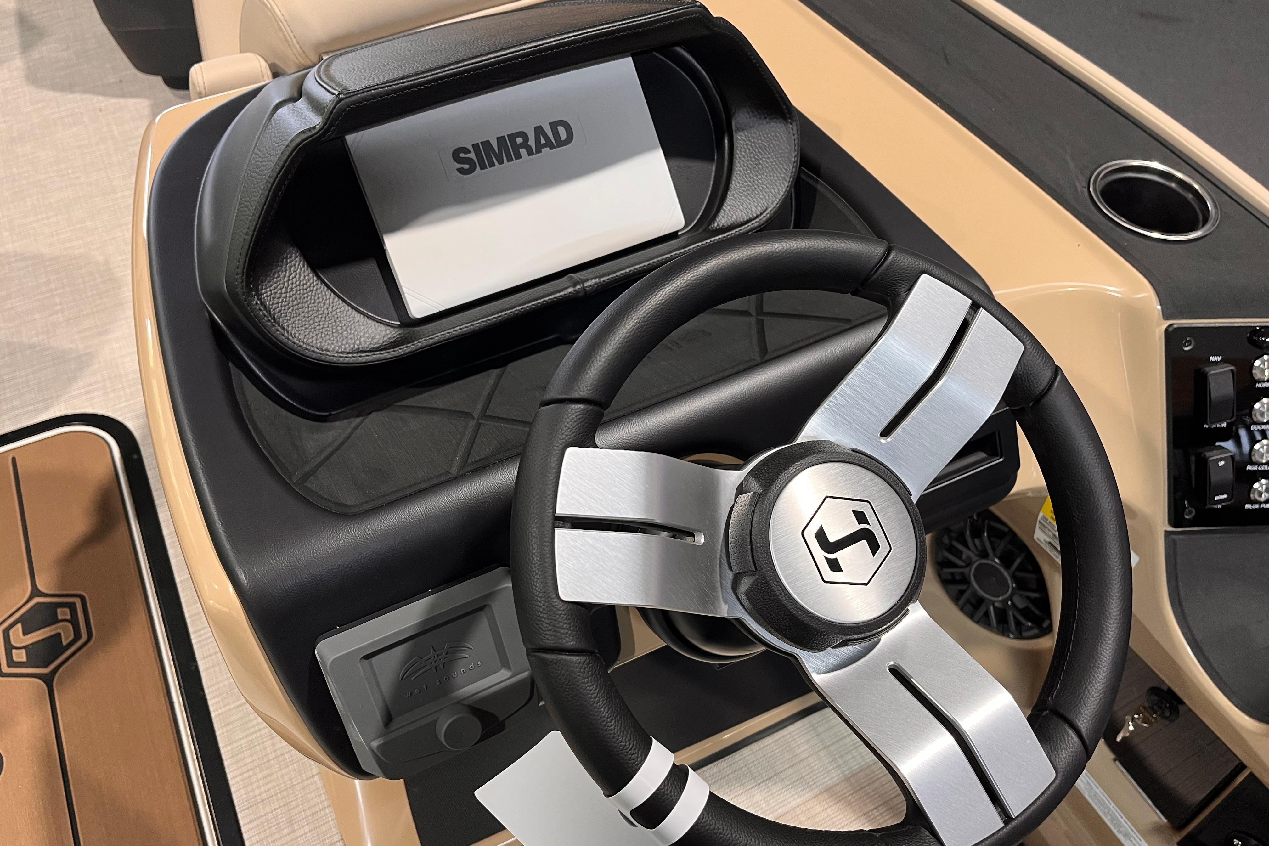 Steering wheel and dashboard of 2026 Harris Sunliner 250 boat with Simrad display.