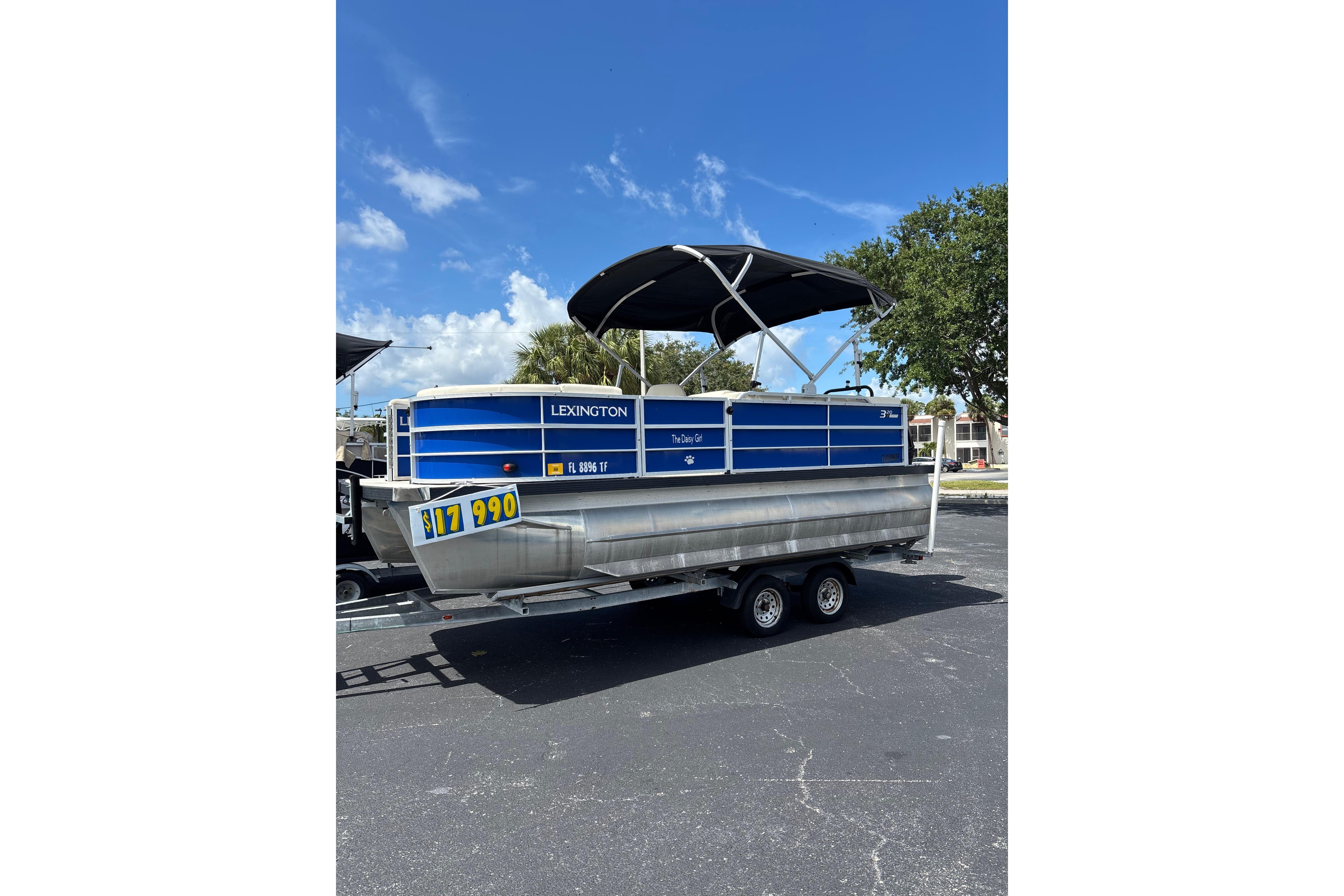 2022 Lexington 323 pontoon boat with blue exterior and canopy on trailer.