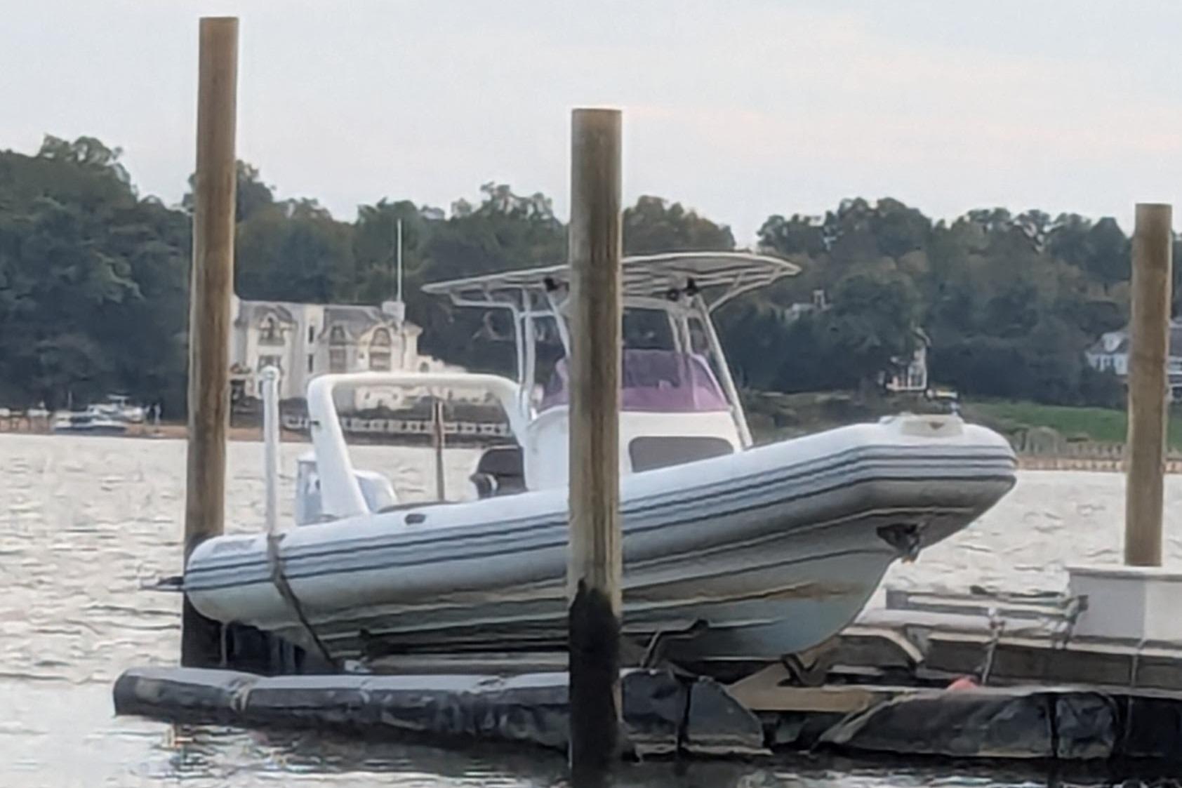 2016 Brig E780 boat docked on a calm waterfront with scenic background.