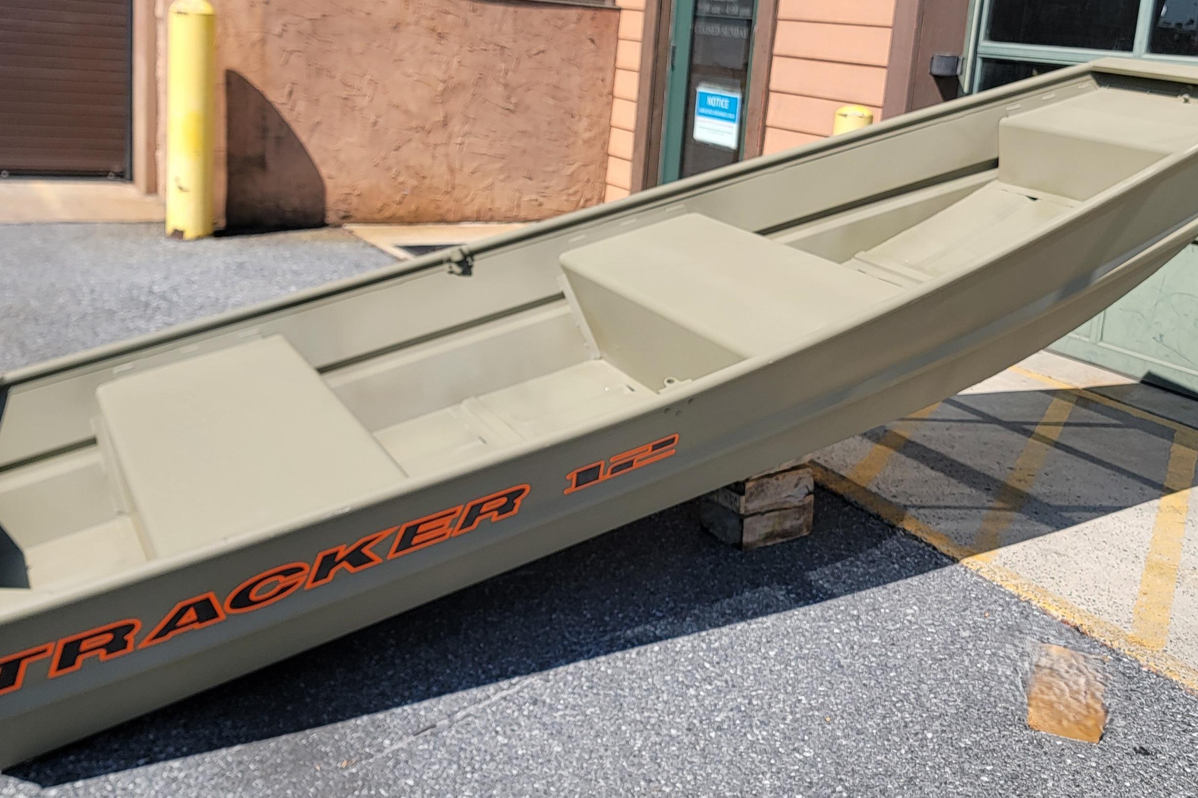 2026 Tracker Grizzly 12 Jon boat displayed outdoors on wooden blocks.