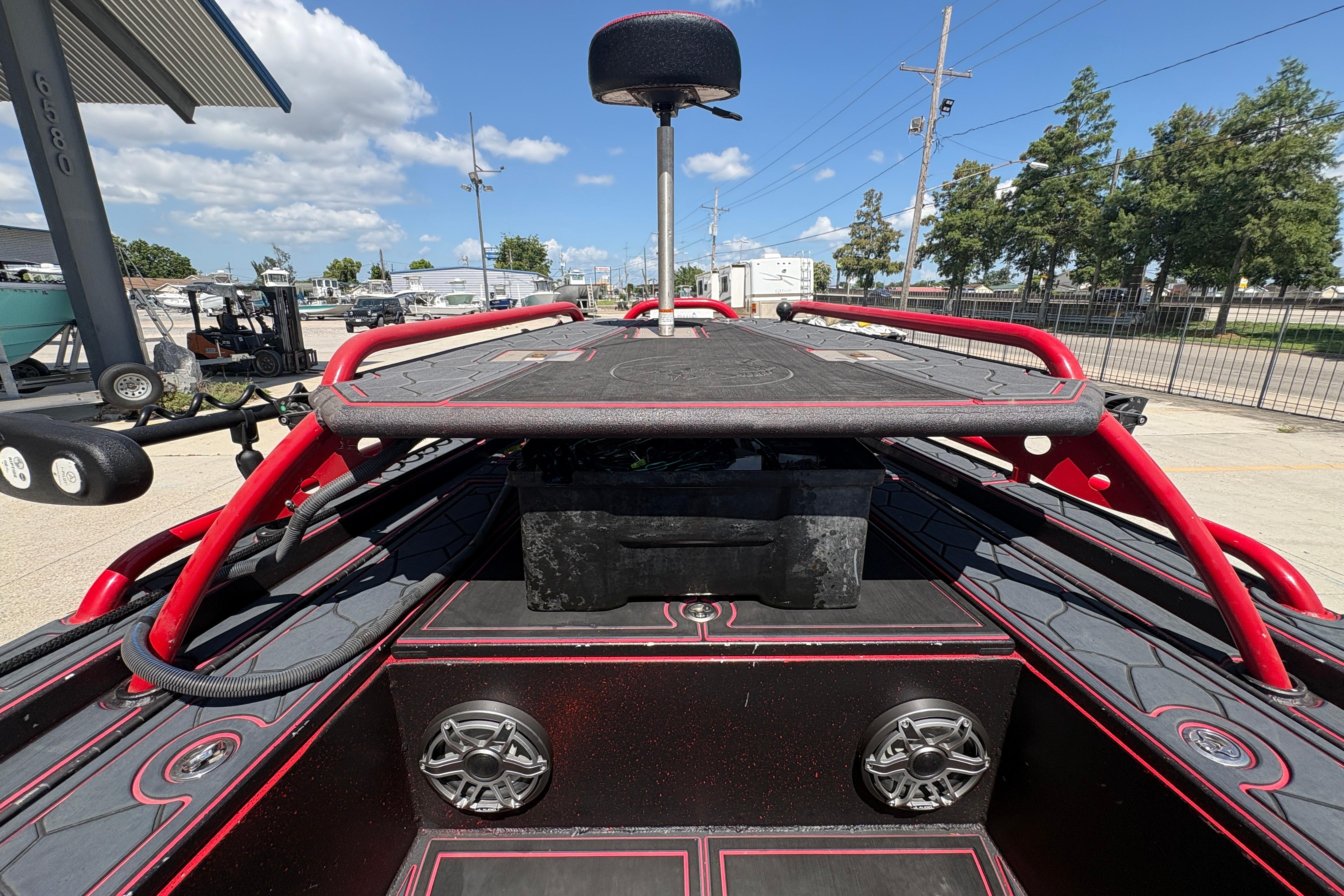 2018 Custom Swamp Shark 24' boat with red accents and speakers, parked outdoors.