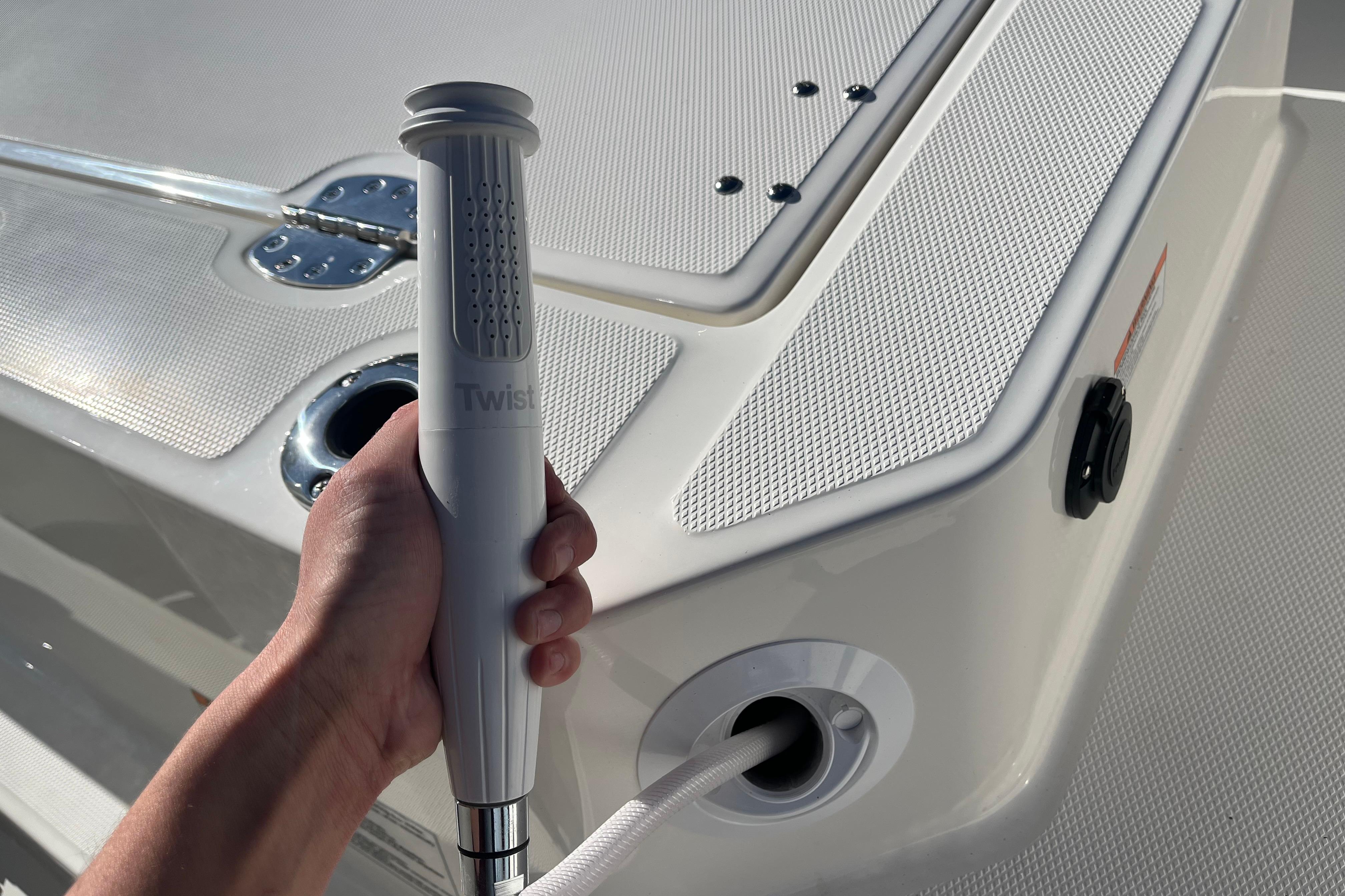 Hand holding a shower handle on a 2026 Boston Whaler 280 Dauntless boat deck.