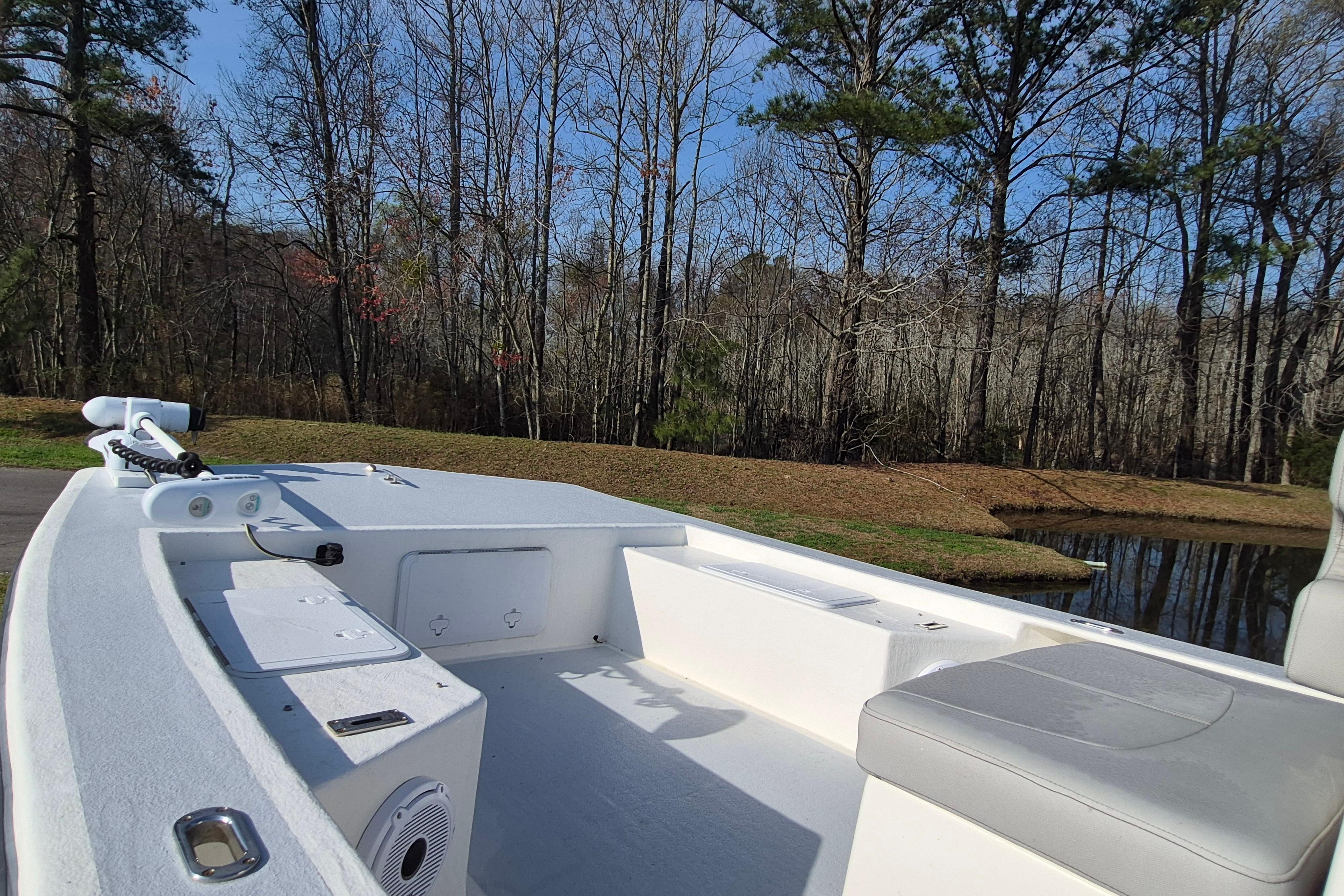 2024 May-Craft 22 Hancock Skiff boat interior with seating, near a wooded pond.