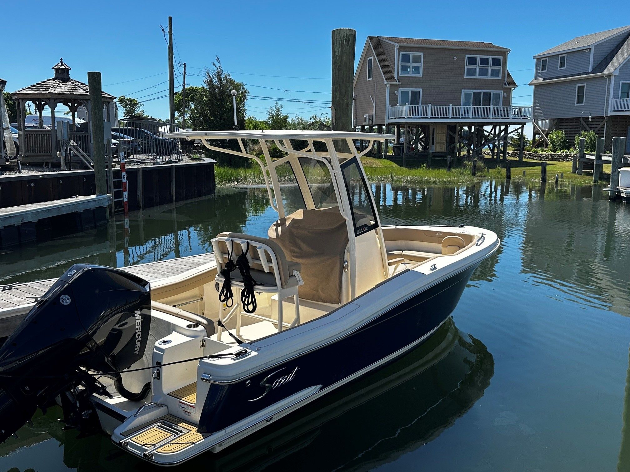 2022 Scout 210XSF boat on water near houses.