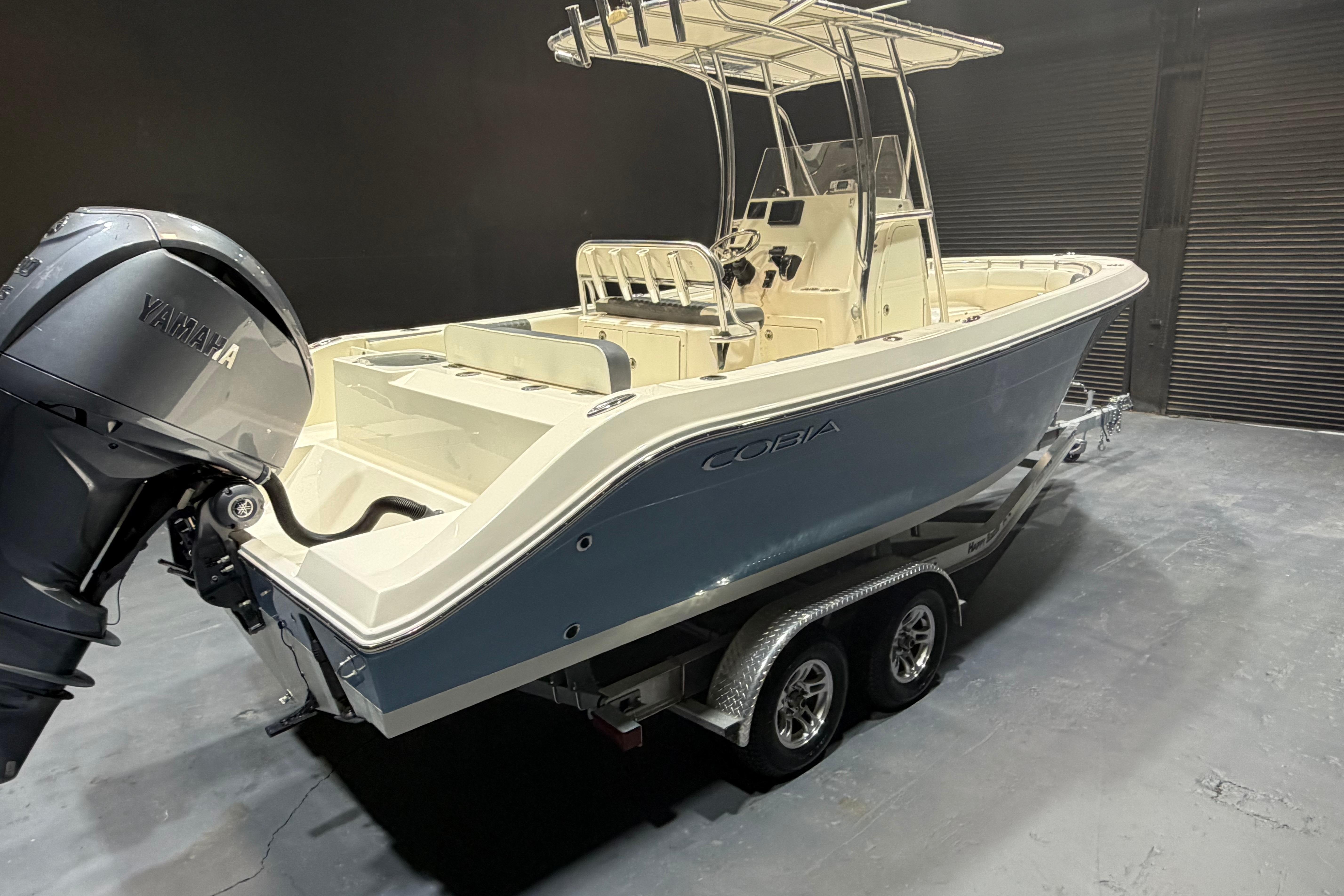 2023 Cobia 237 Center Console boat with Yamaha engine on trailer in showroom.