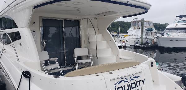 2010 Meridian 441 Sedan yacht docked at marina, featuring spacious deck and seating area.