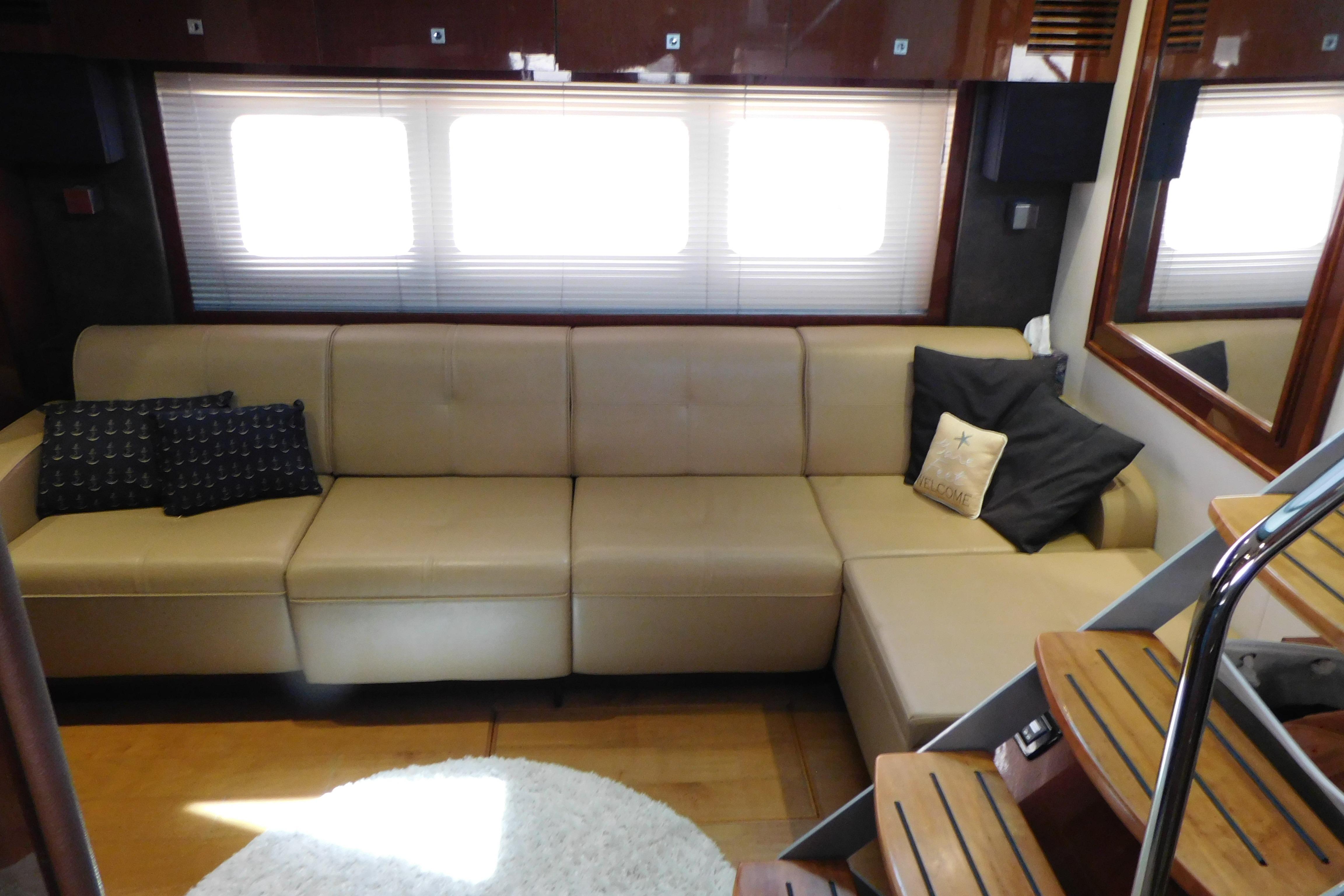 Luxurious interior of 2013 Sea Ray 510 Sundancer yacht with beige leather sofa.