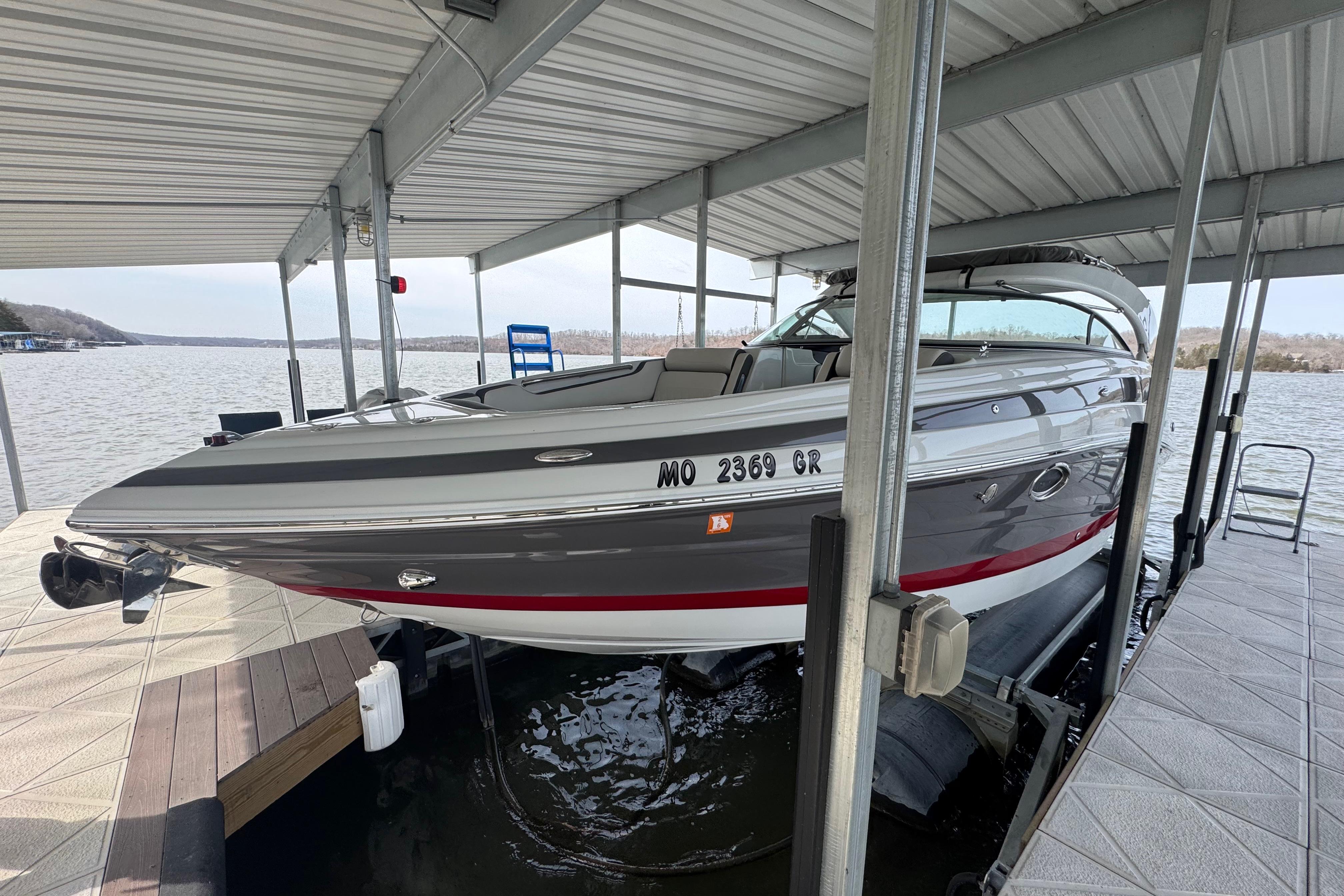 2022 Crownline 265 SS boat docked under a covered marina on a lake.