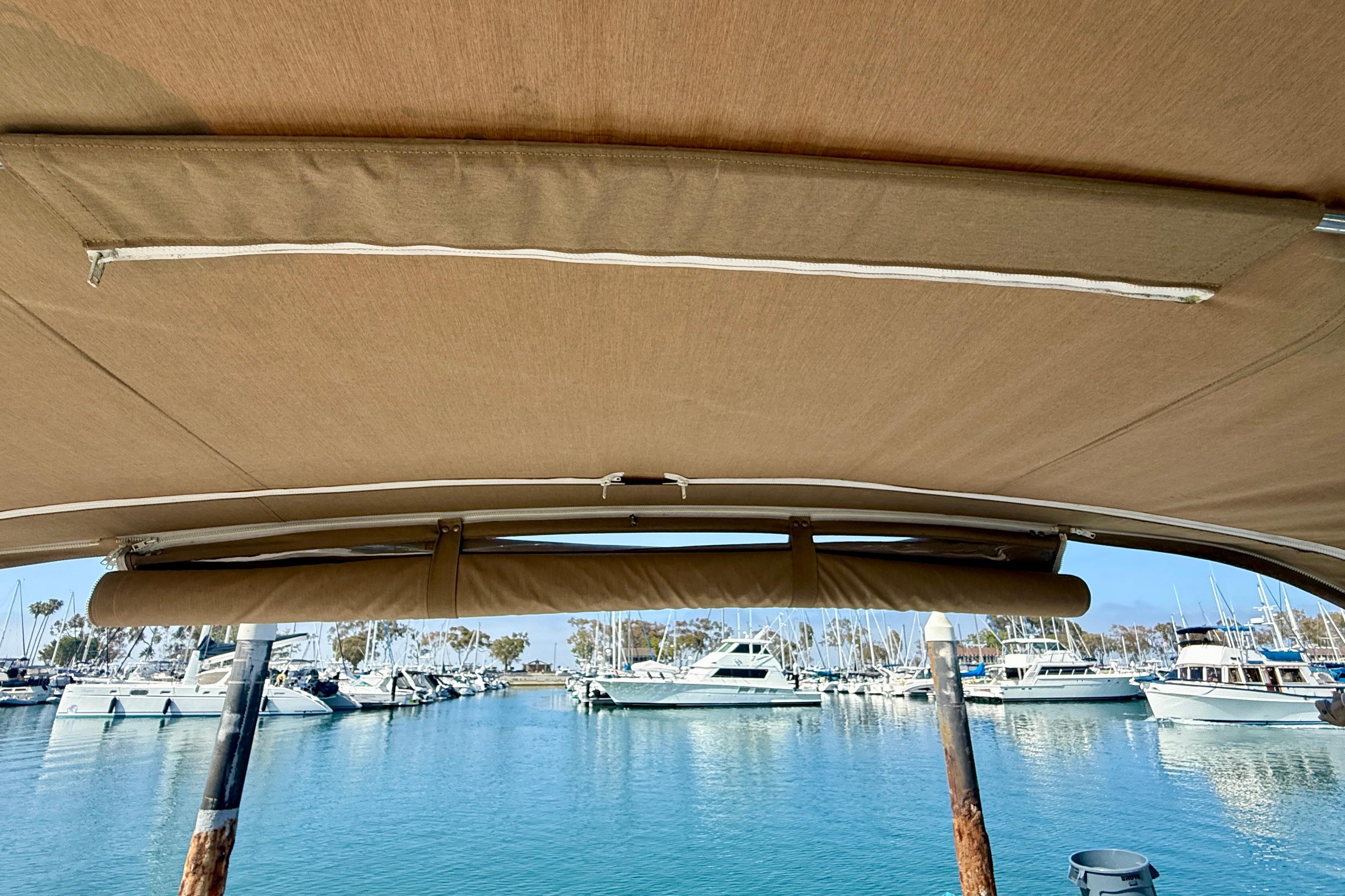 1998 Tiara Yachts 3500 Express with canopy, docked in a marina with other boats.