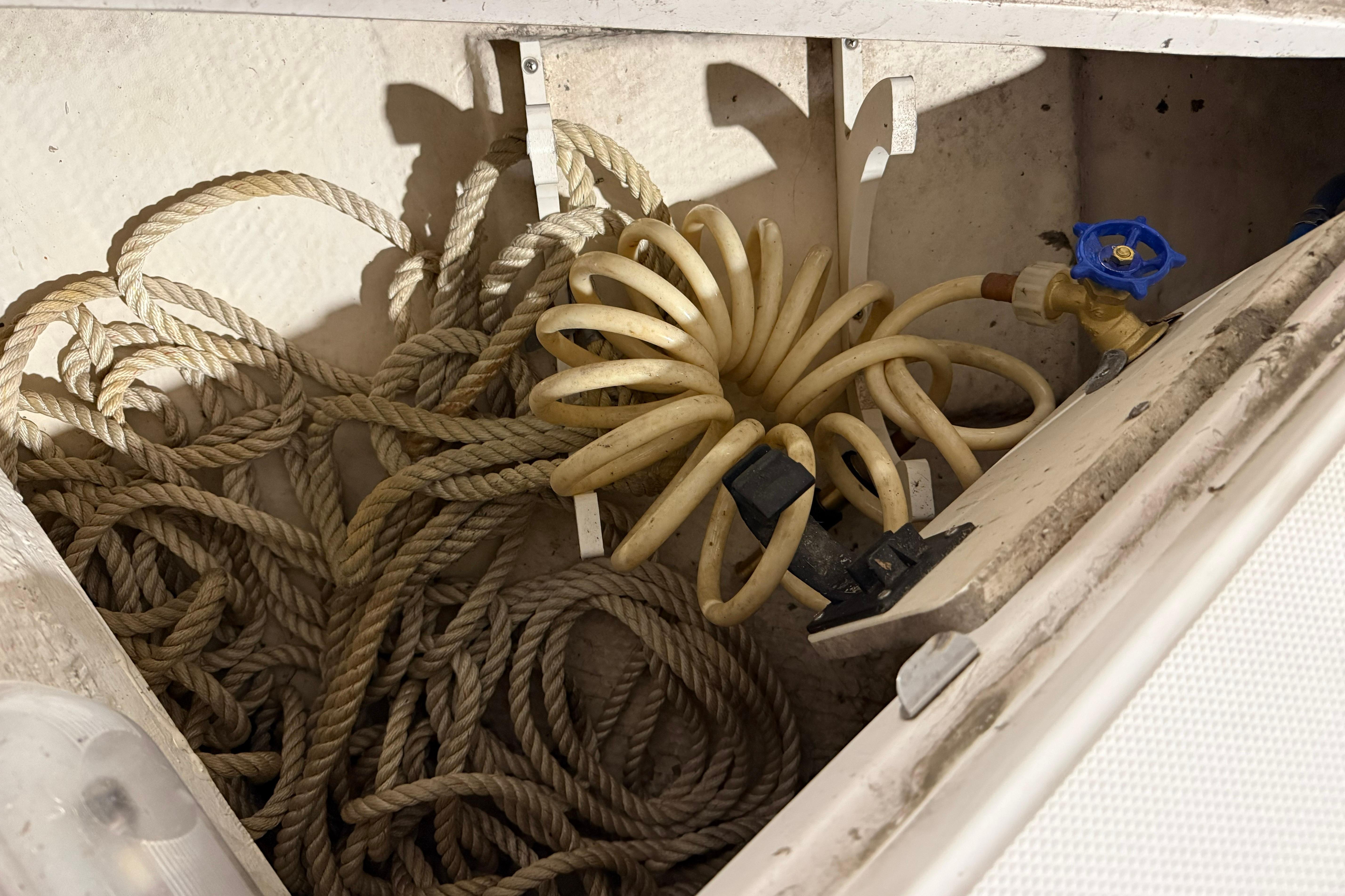 Storage compartment of 2007 Regal Commodore 3760 IO with coiled hose and ropes.