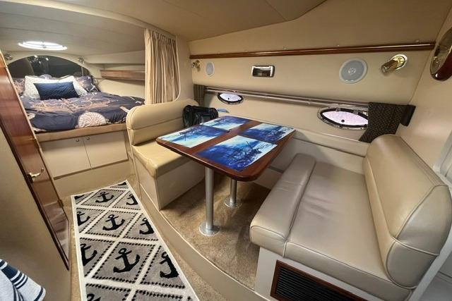 2004 Cruisers Yachts 3372 Express cabin interior with dining area and cozy sleeping quarters.