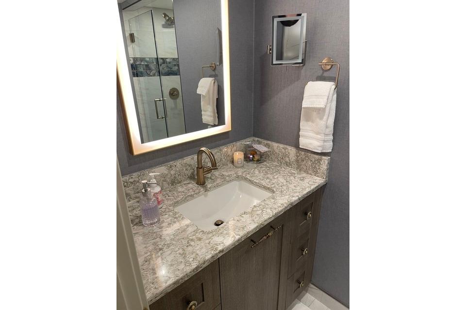 Luxurious bathroom vanity with marble countertop and illuminated mirror on Adonia's 2021 Queen Elizabeth.