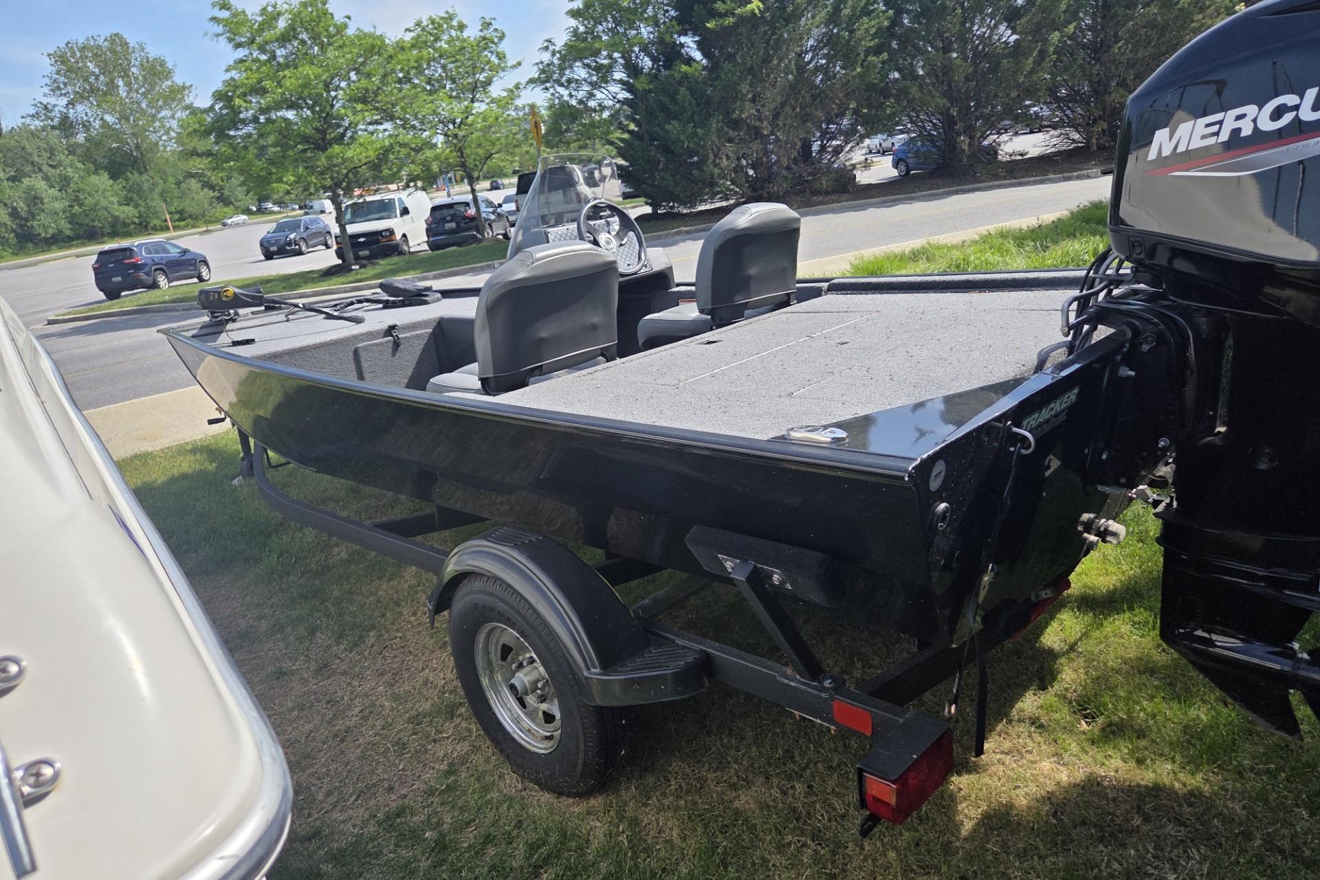 2024 TRACKER MARINE CLASSIC XL boat with Mercury engine on trailer, parked outdoors.