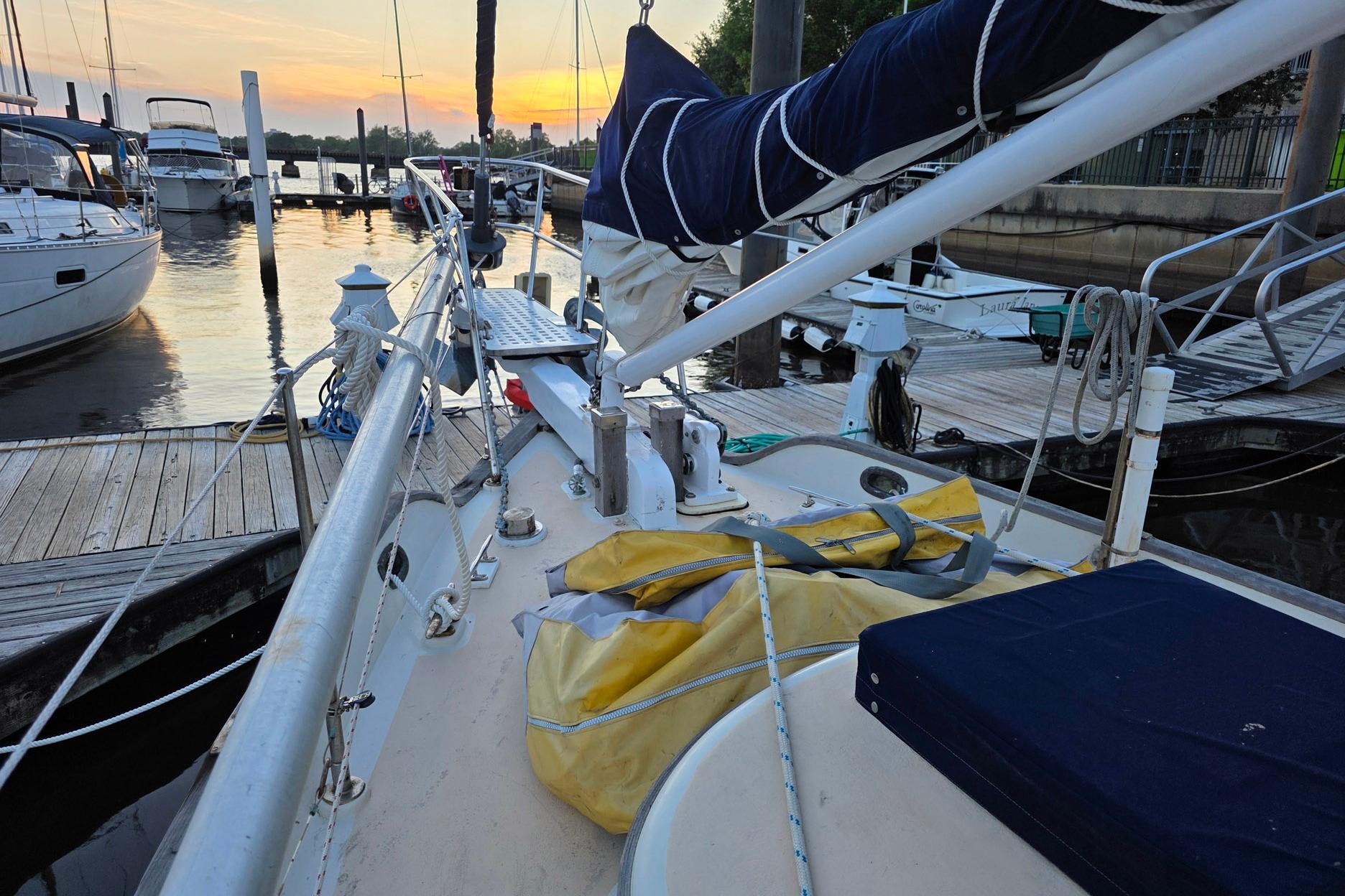 1982 Tayana 37 sailboat docked at marina during sunset.