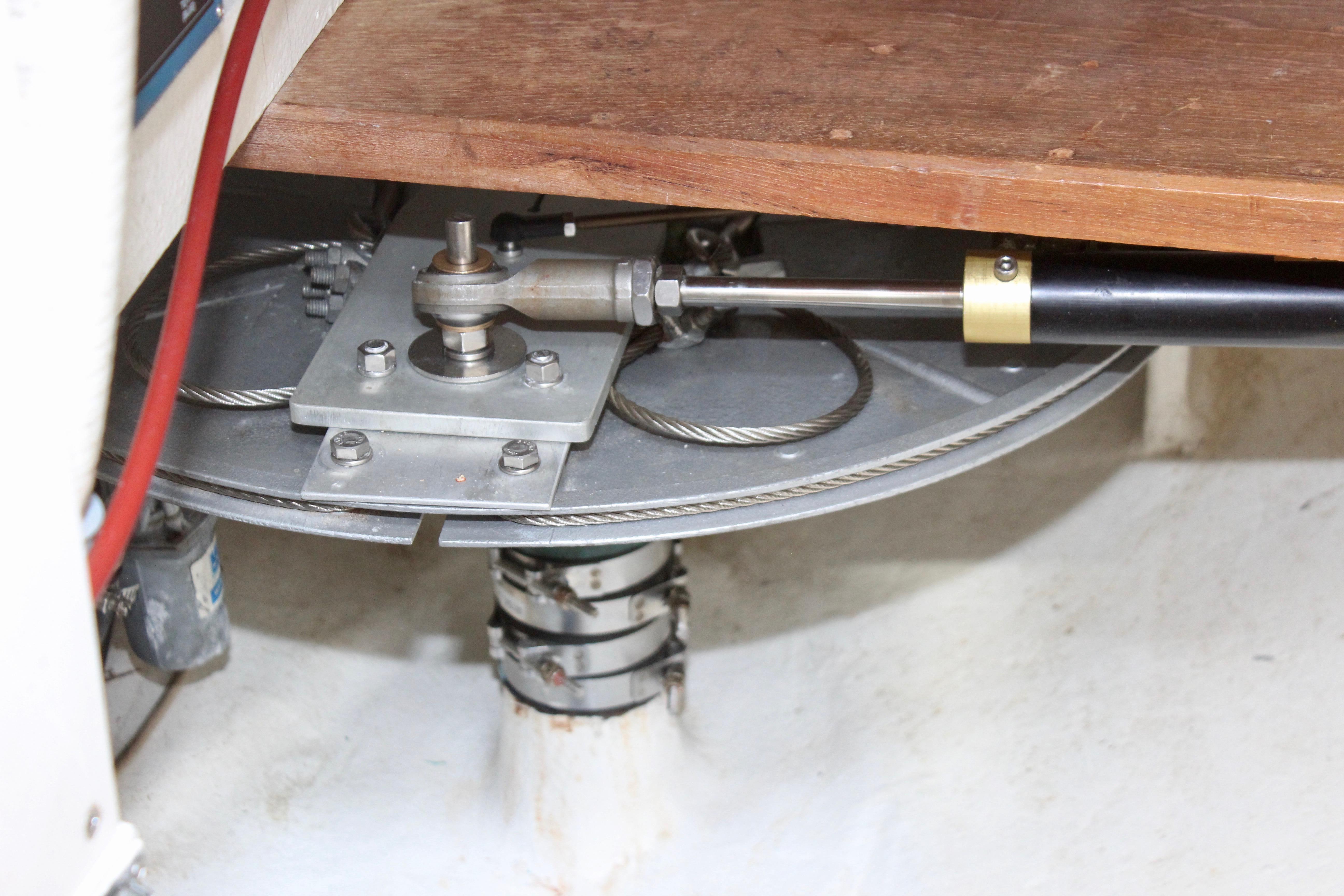 Steering mechanism of a 1993 Freya 39 sailboat, featuring cables and hydraulic components.