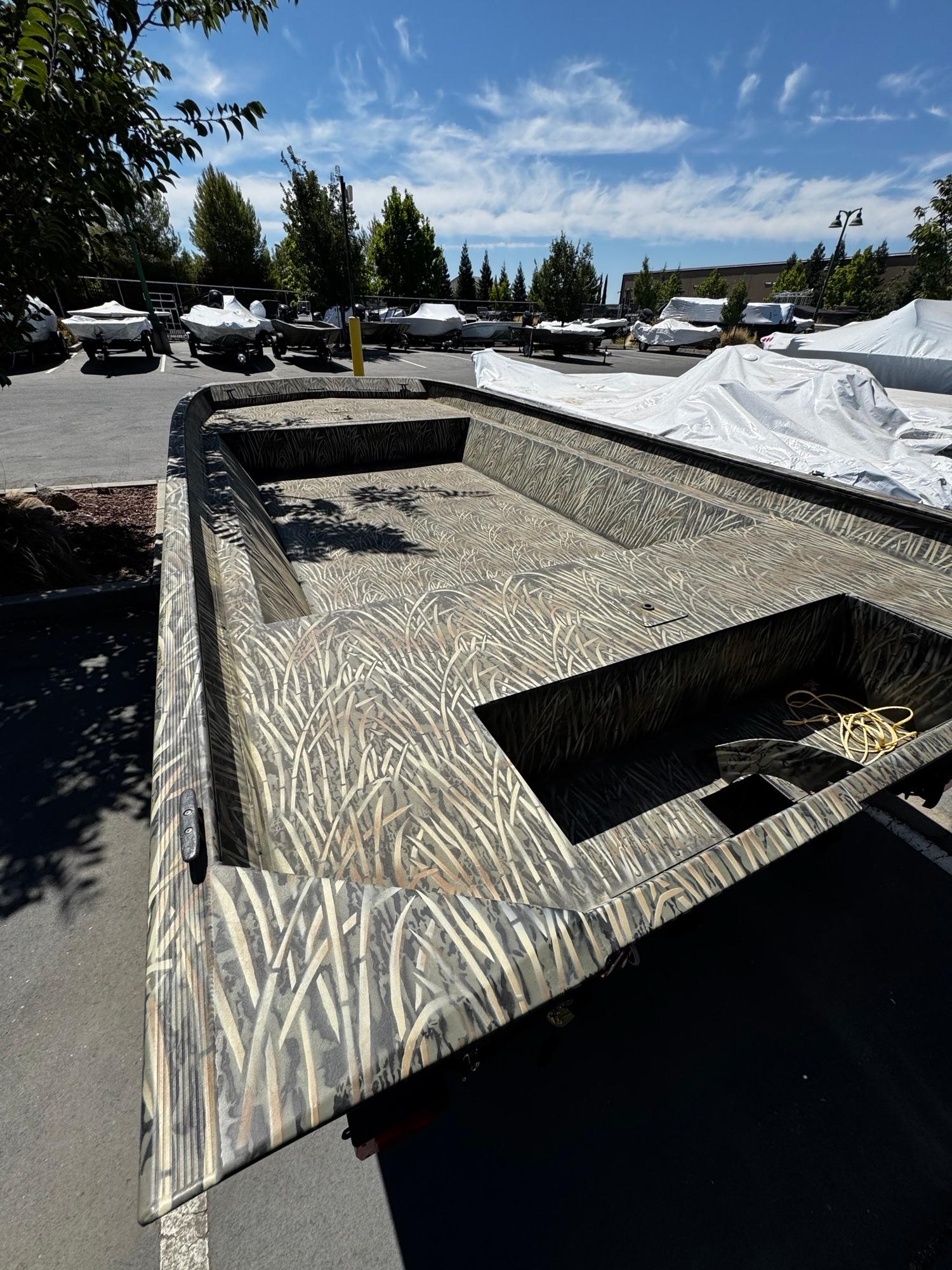 2025 Tracker GRIZZLY 2072 Utility boat with camouflage design in outdoor setting.