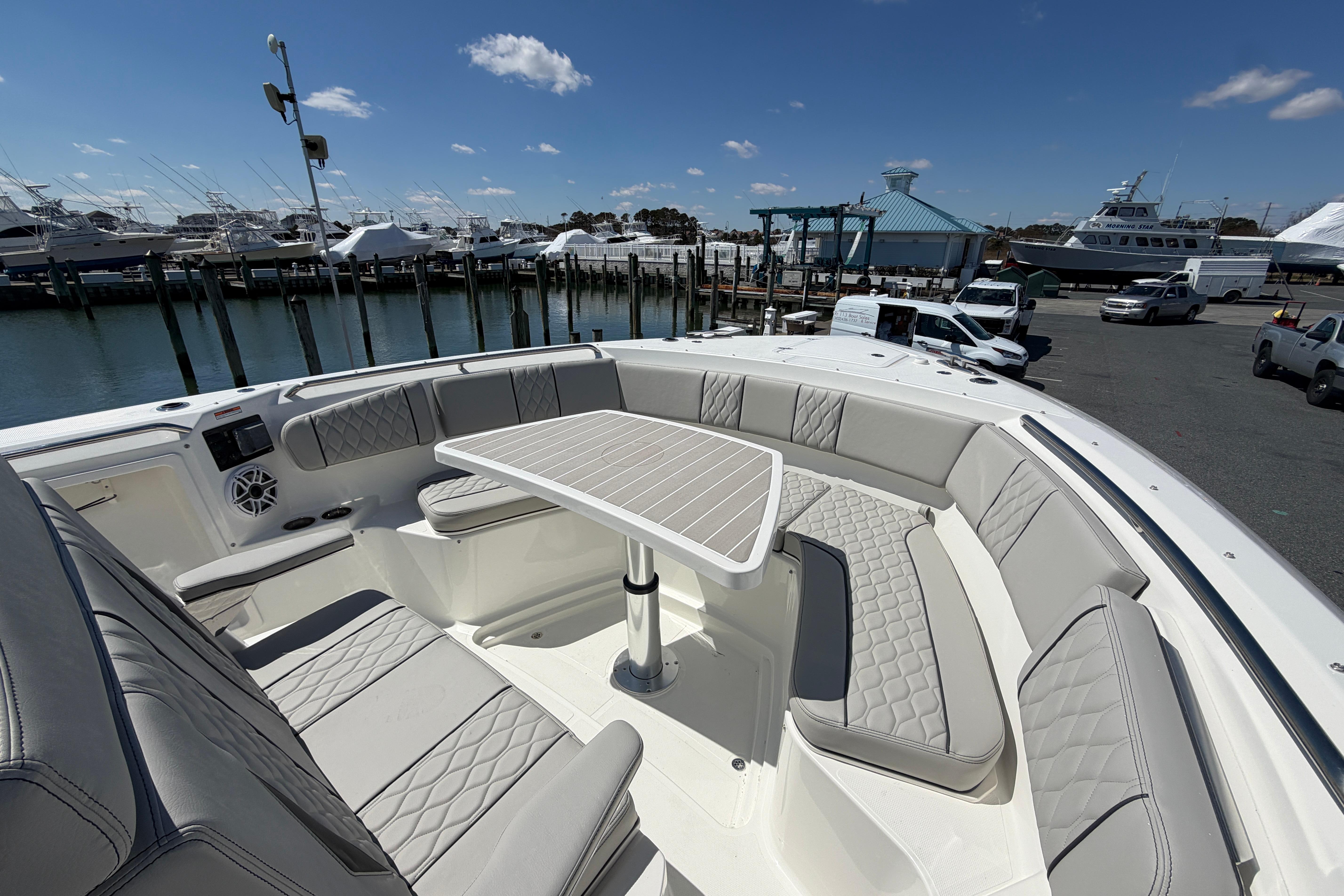 Luxurious seating area on 2026 Pursuit S 358 Sport boat, docked at marina.