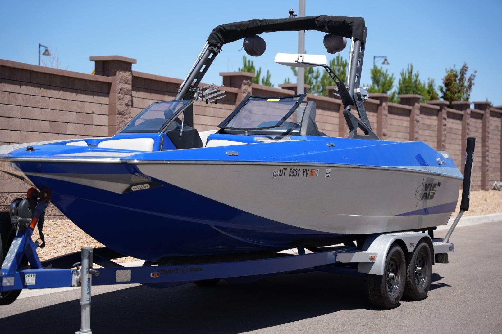 2015 Axis A24 boat in blue and white on a trailer, parked outdoors.