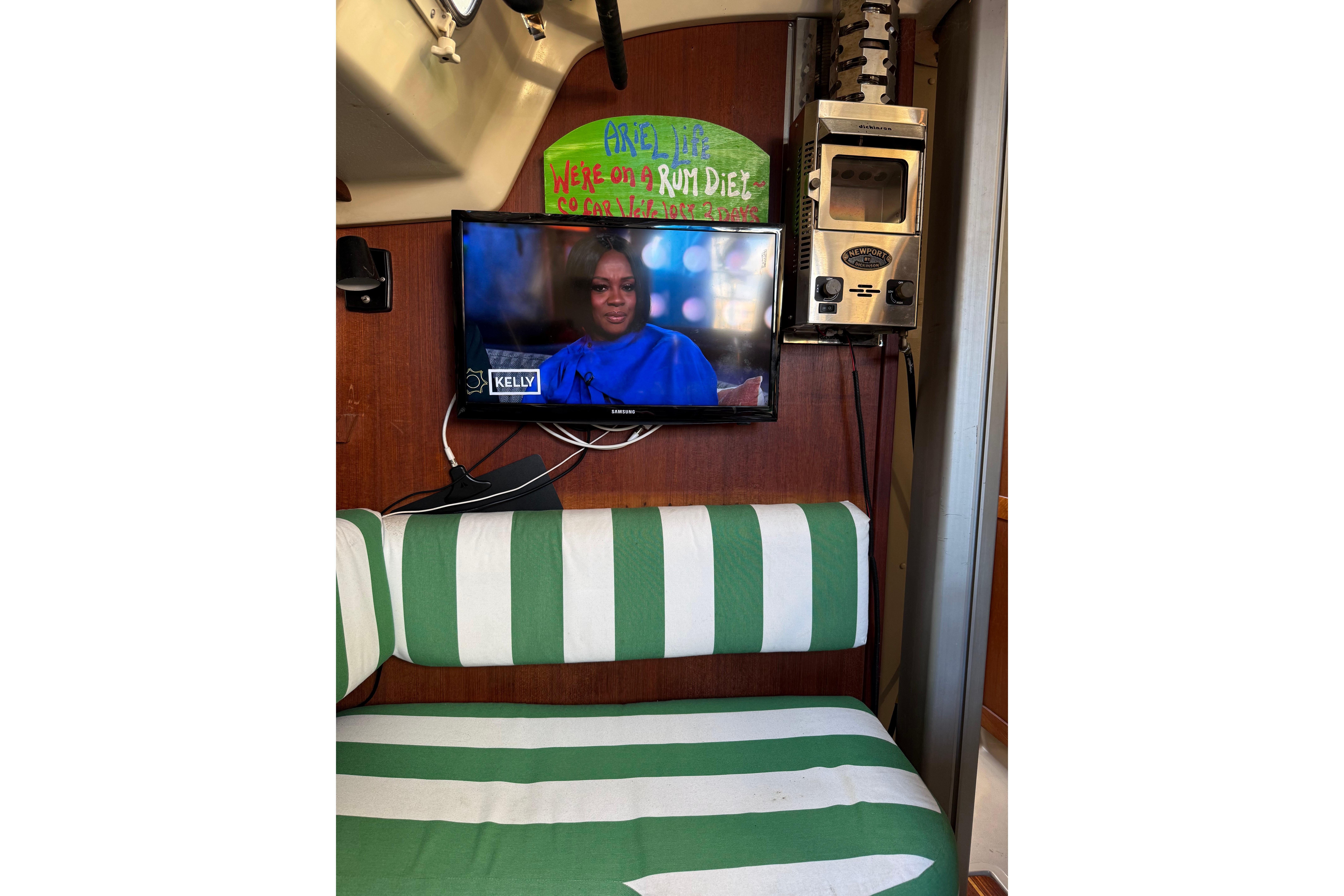 Interior of 1983 O'Day 34 sailboat with TV and striped seating.