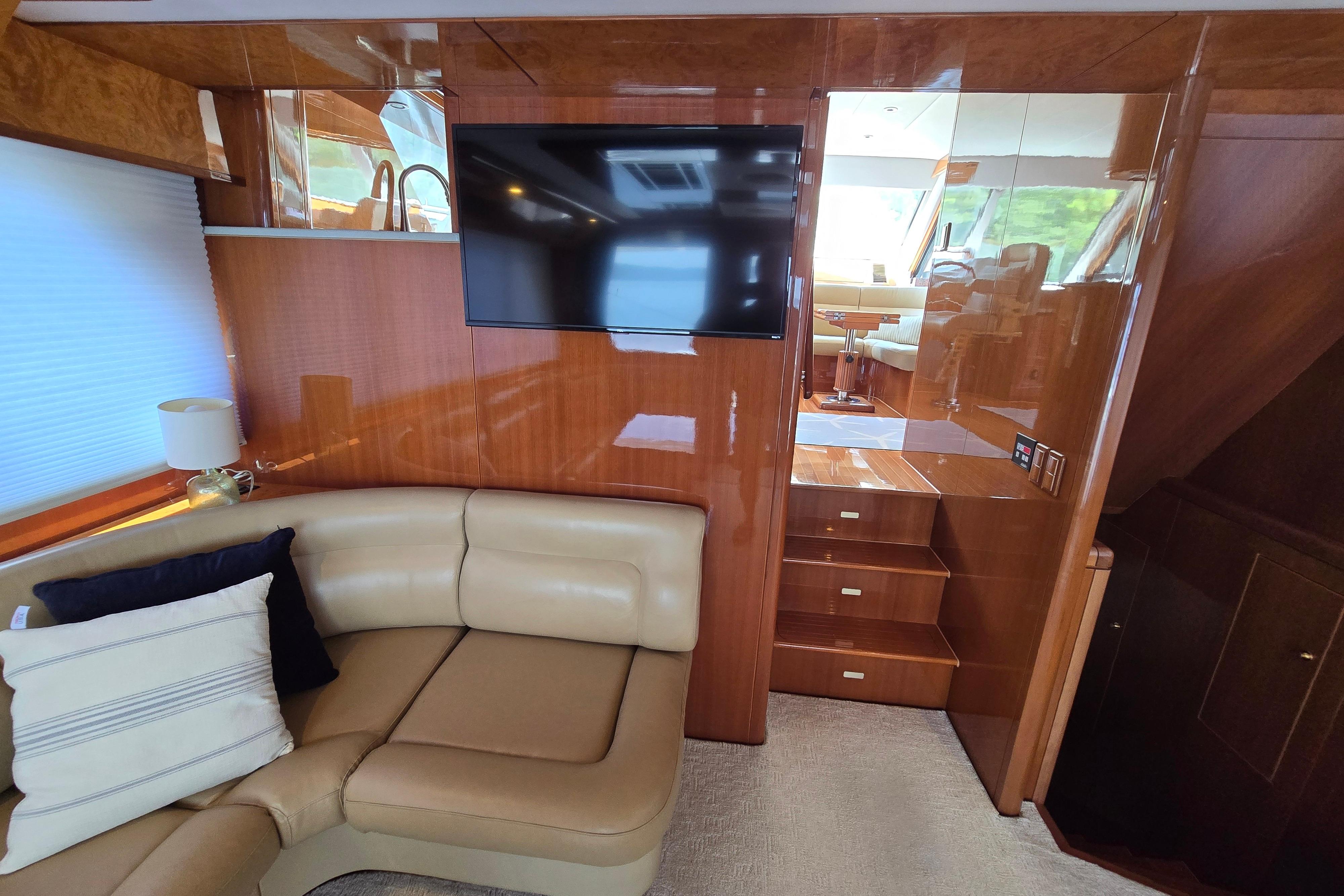 Luxurious interior of 2004 Grand Harbour 58 yacht with leather seating and mounted TV.