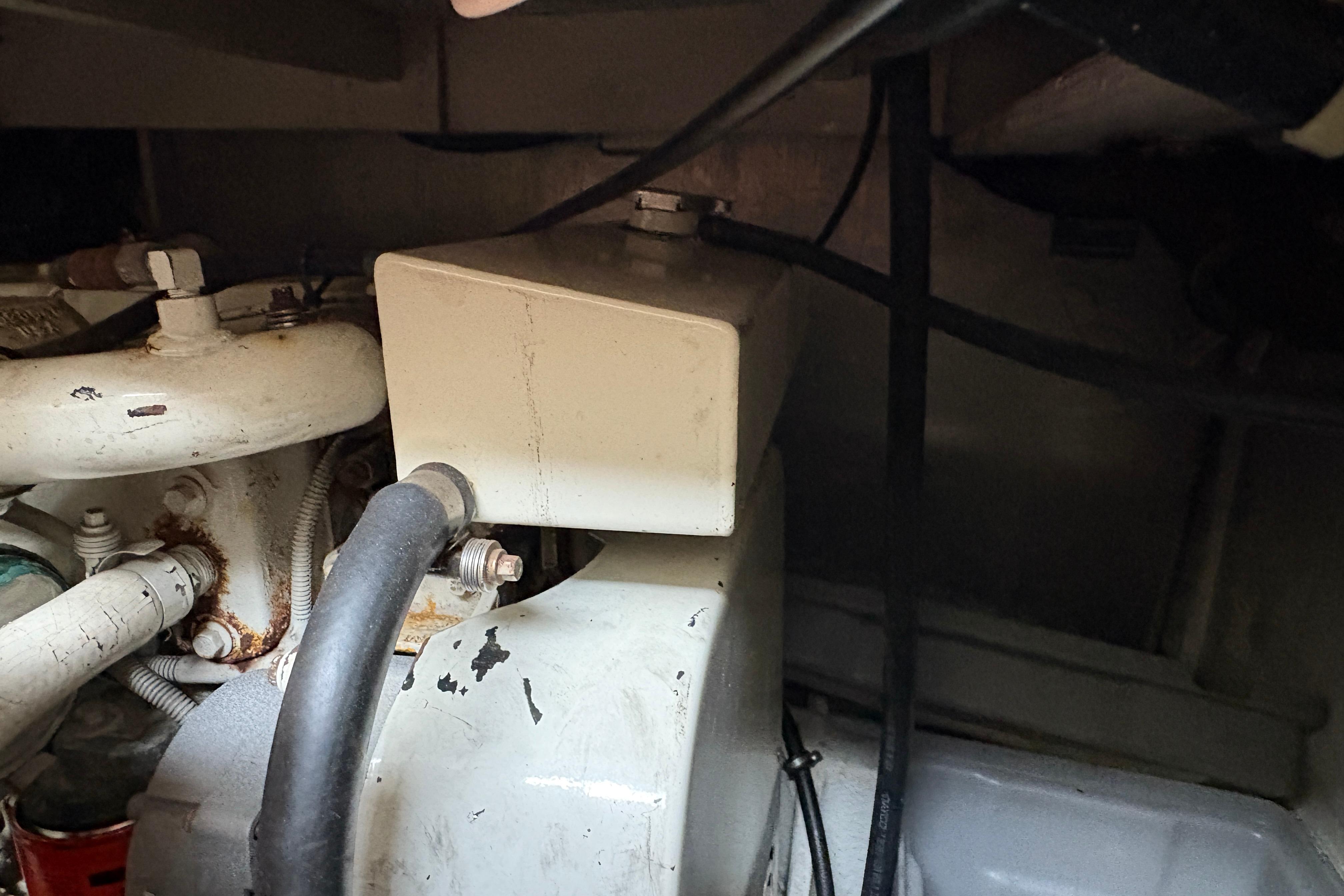 Engine compartment of 1988 Bayliner 3587 Motoryacht showing mechanical components and hoses.