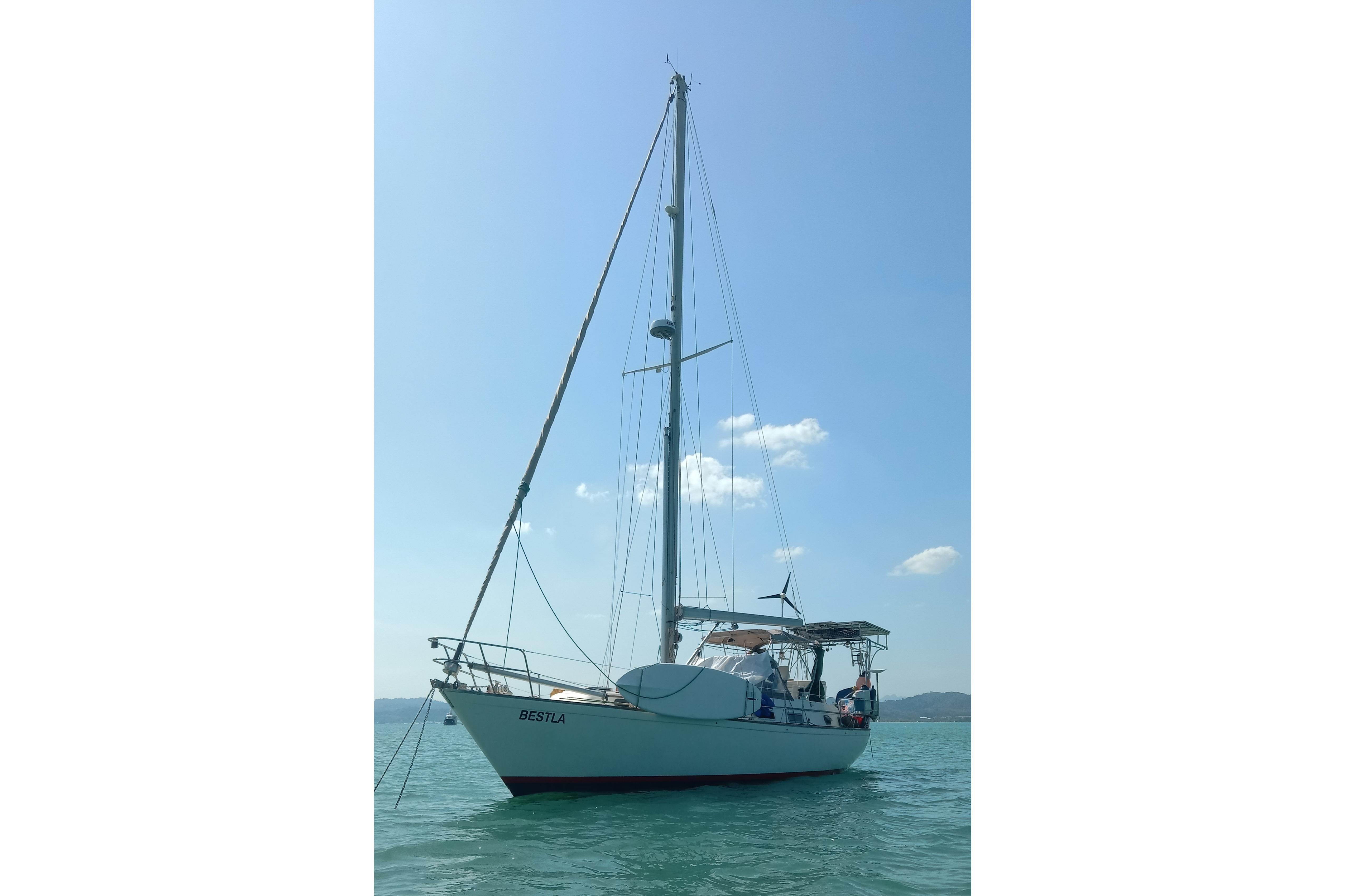 1984 Pearson 385 sailboat on calm water under clear blue sky.