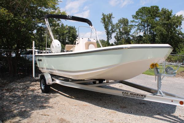 2023 Sundance DX20 boat on trailer, parked outdoors, under clear sky.