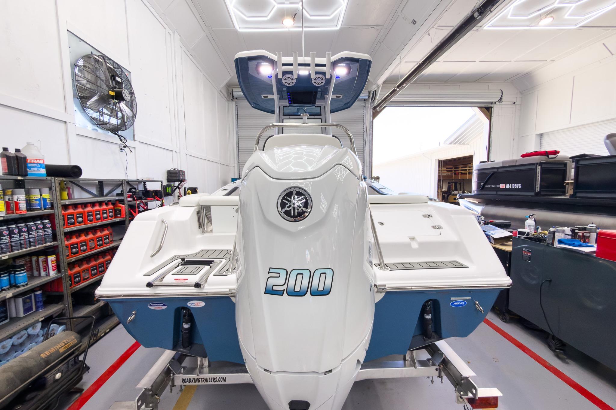 The image shows a Tidewater 220 LXF boat in a workshop.