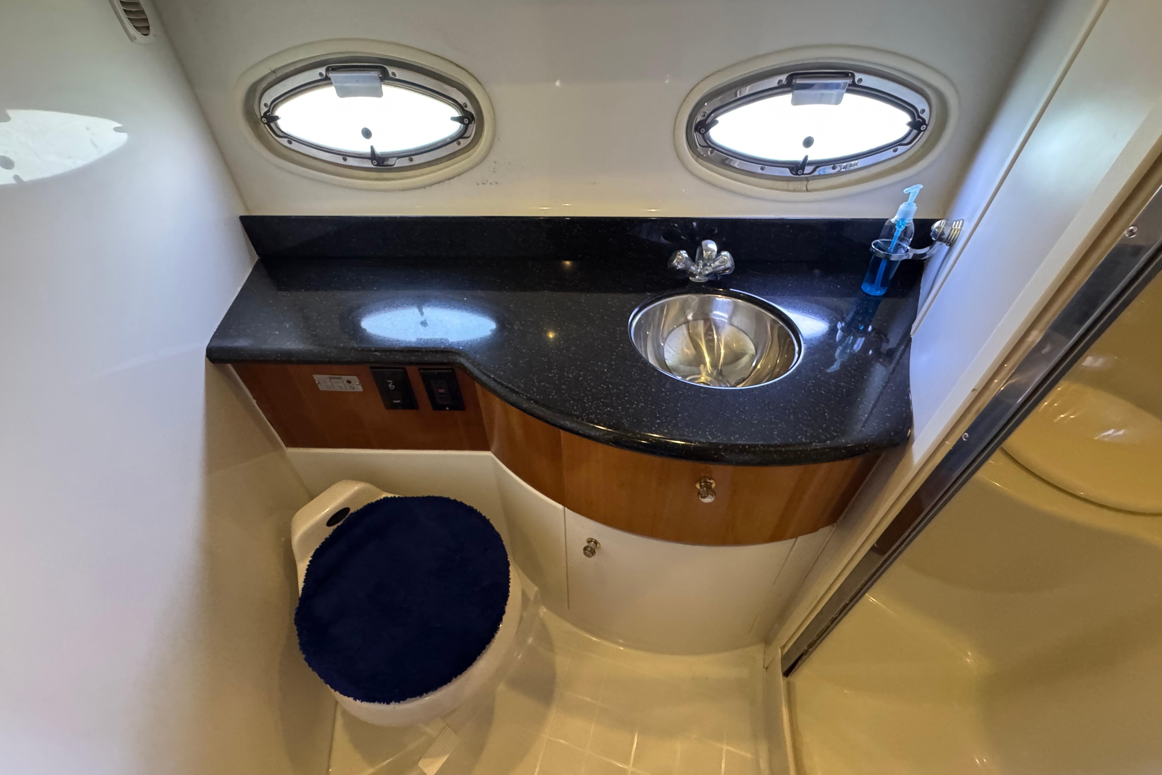 Bathroom interior of 2002 Carver 396 Motor Yacht with sink and porthole windows.