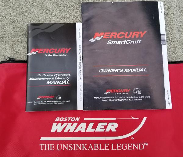 Manuals for Mercury SmartCraft and Boston Whaler 235 Conquest, 2011, on red Boston Whaler bag.