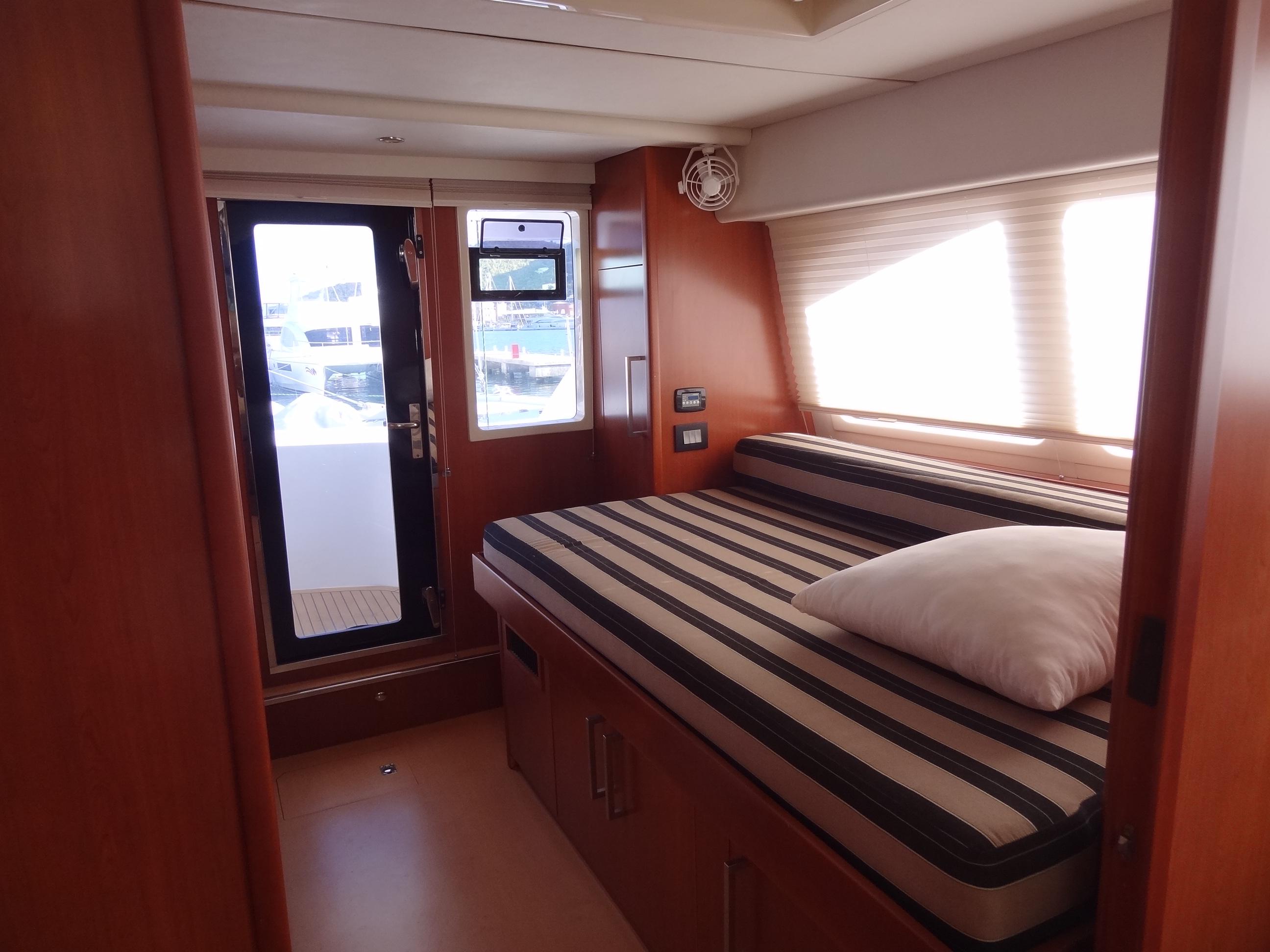 2014 Leopard 58 yacht interior cabin with striped bedding and wooden finishes
