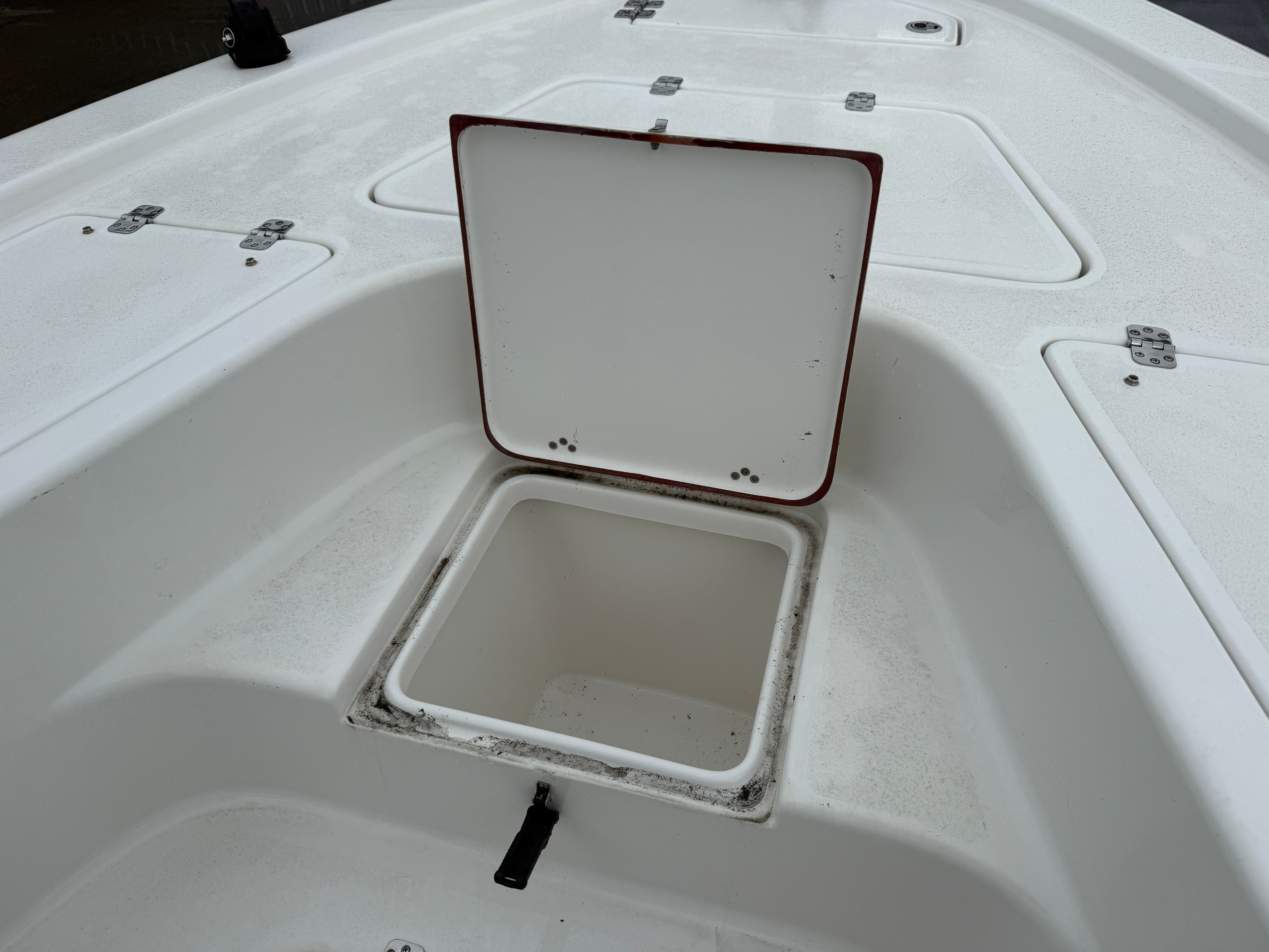 An open storage compartment on a white boat.