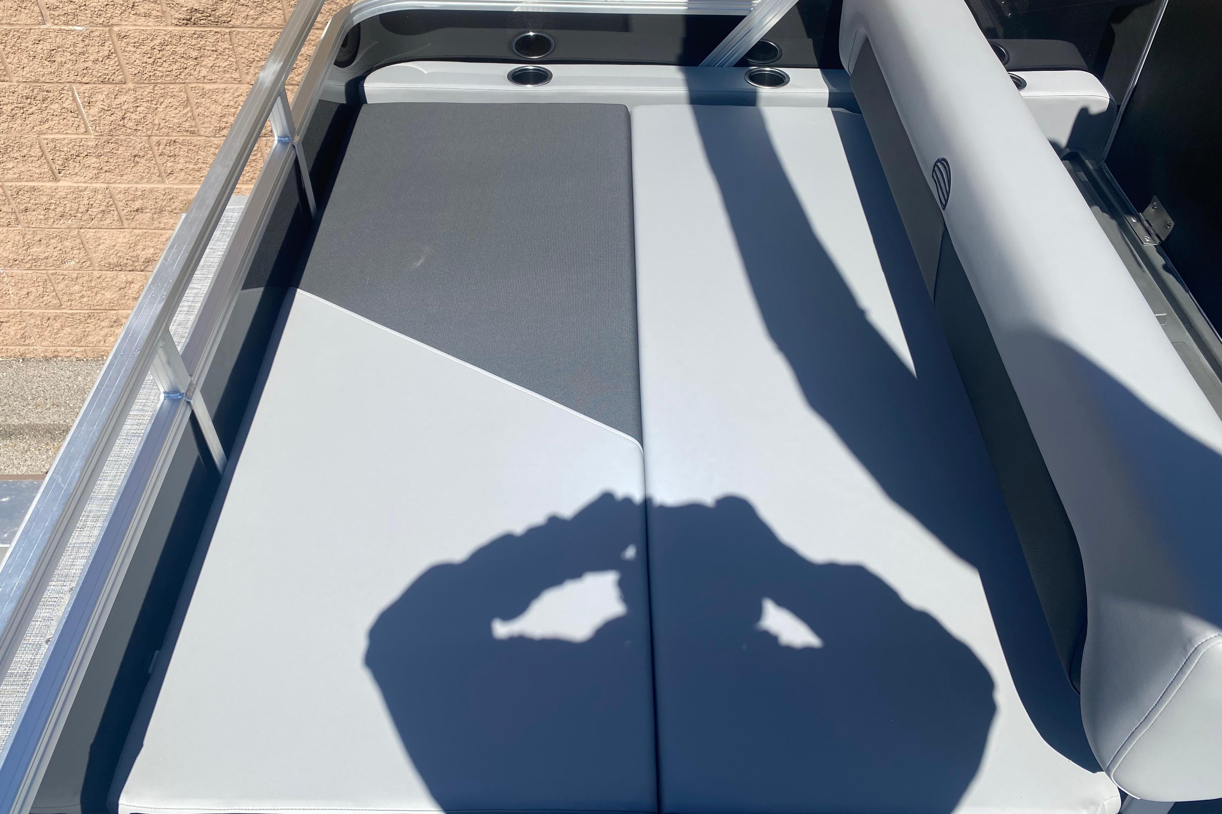 2026 Sun Tracker Party Barge 22 RF DLX boat interior with cushioned seating and cup holders.
