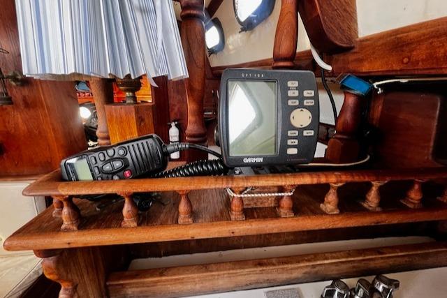 Wooden boat interior with navigation equipment, including a Garmin device and radio, on a 1978 Fantasia Cutter.