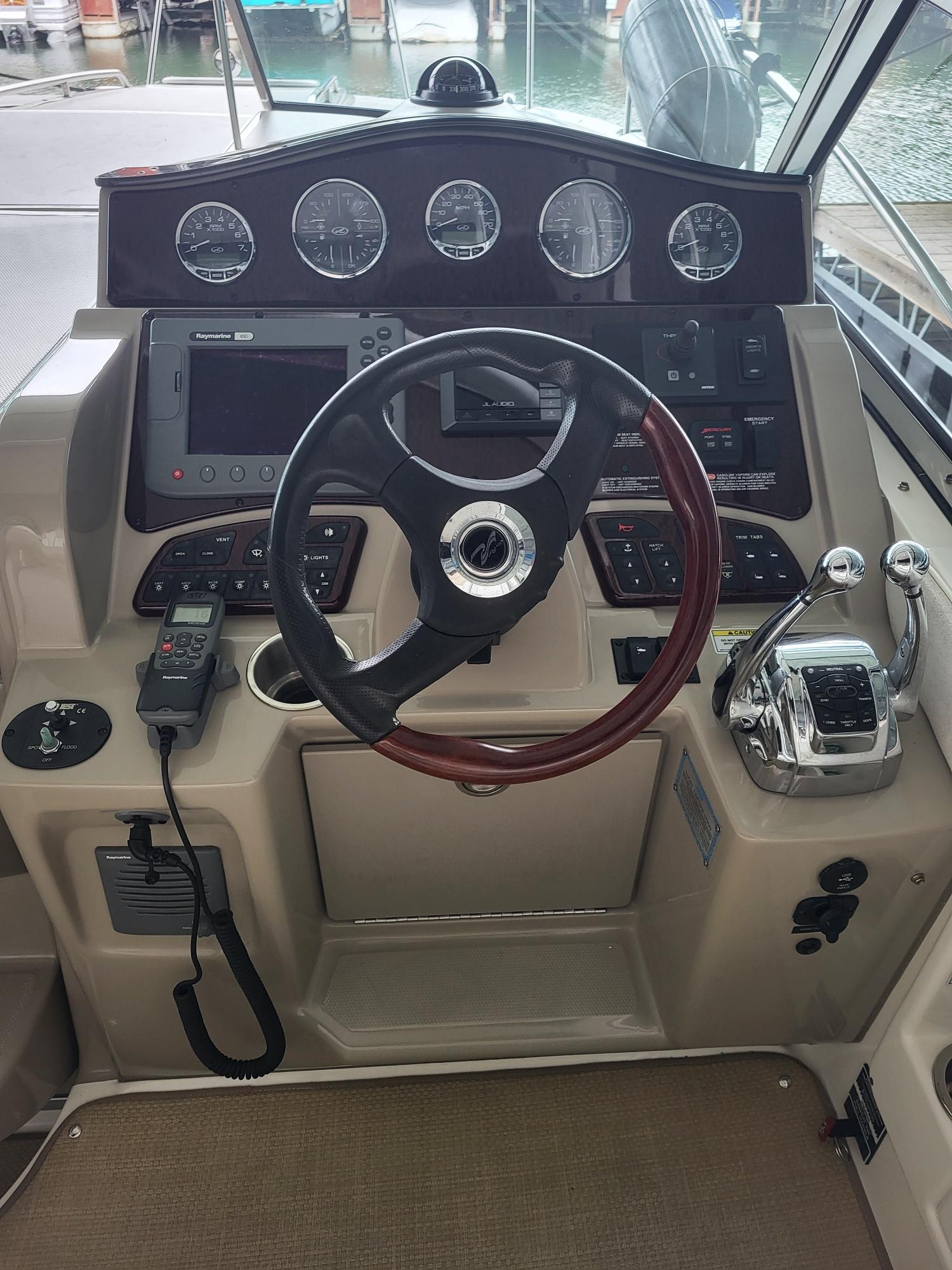 2009 Sea Ray 310 Sundancer helm with steering wheel, gauges, and controls.
