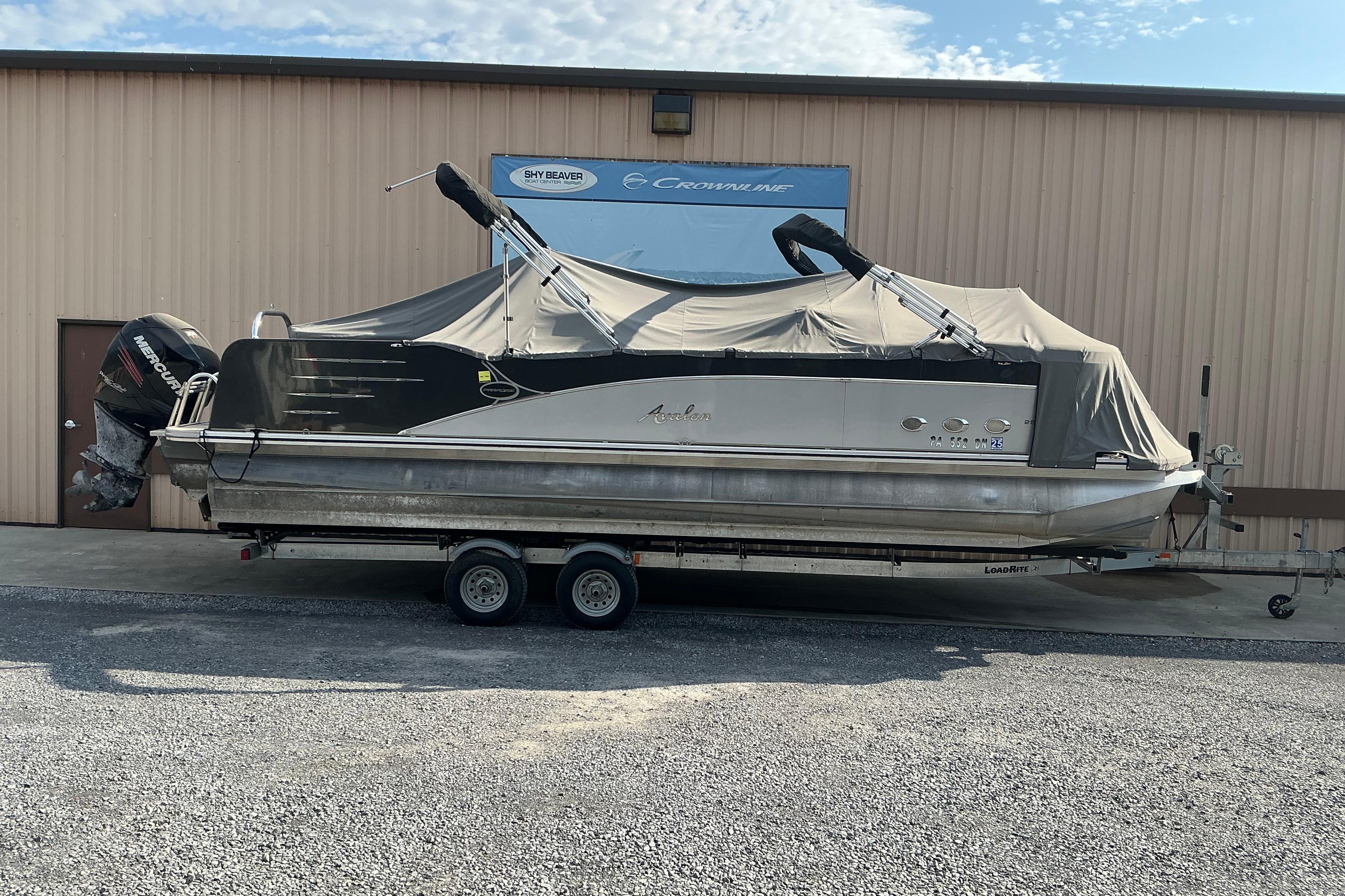 2014 Avalon 25 ft. Paradise Elite pontoon boat on trailer, covered and parked outside.