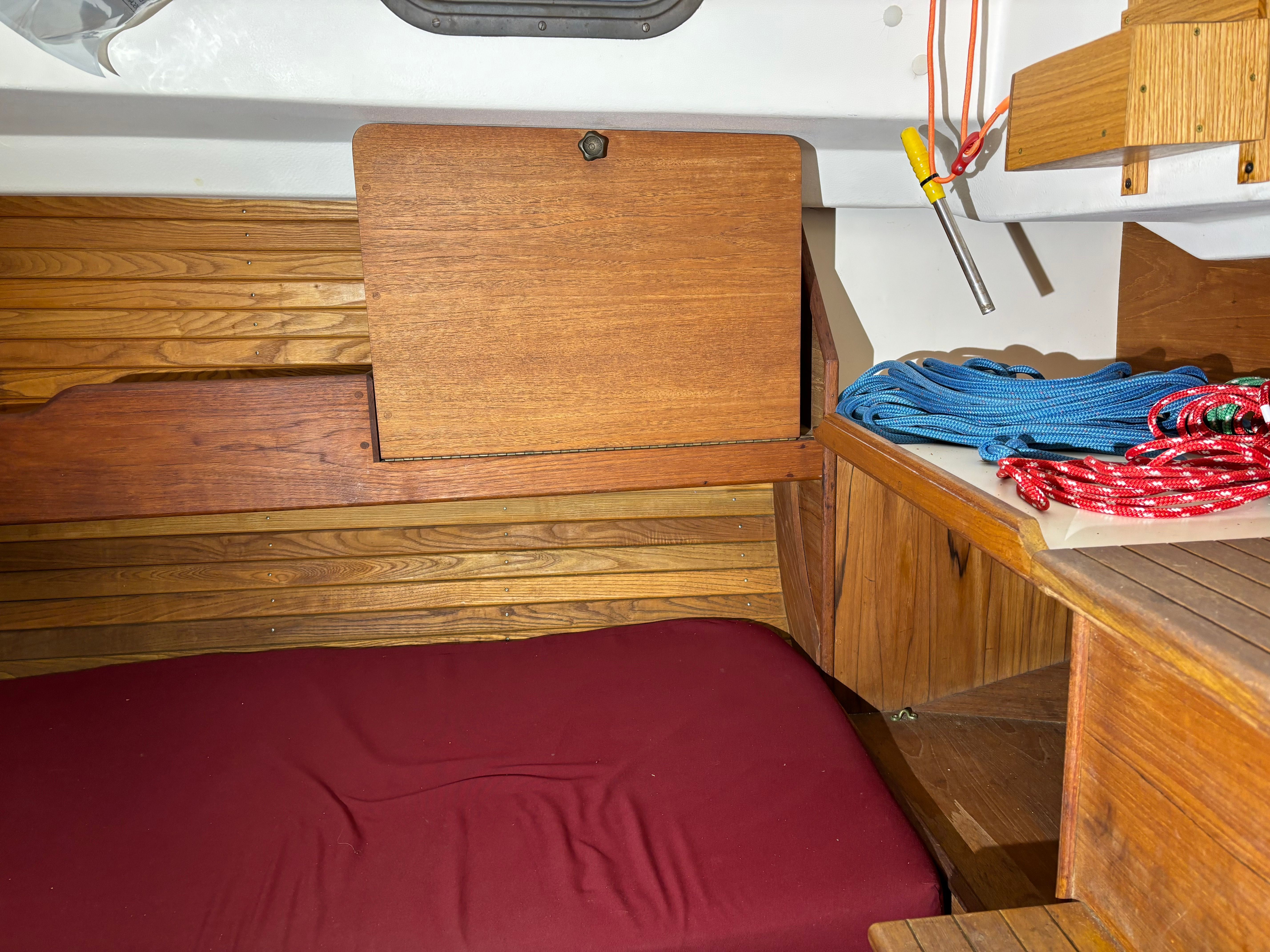 Interior of a 1986 Cape Dory 26 yacht with ropes and wood paneling.