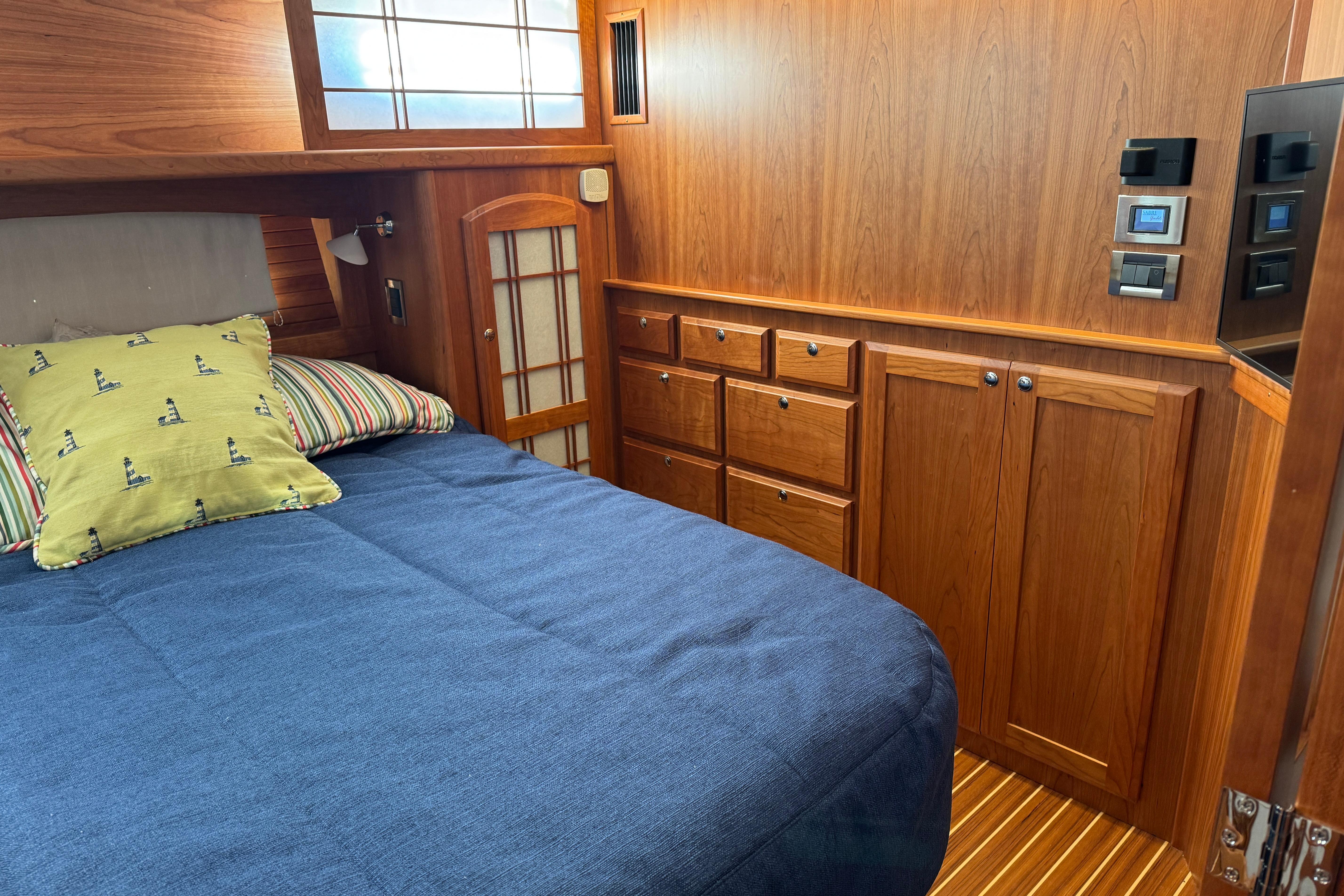 2023 Sabre 48 Salon Express cabin with wooden interior and cozy bedding.