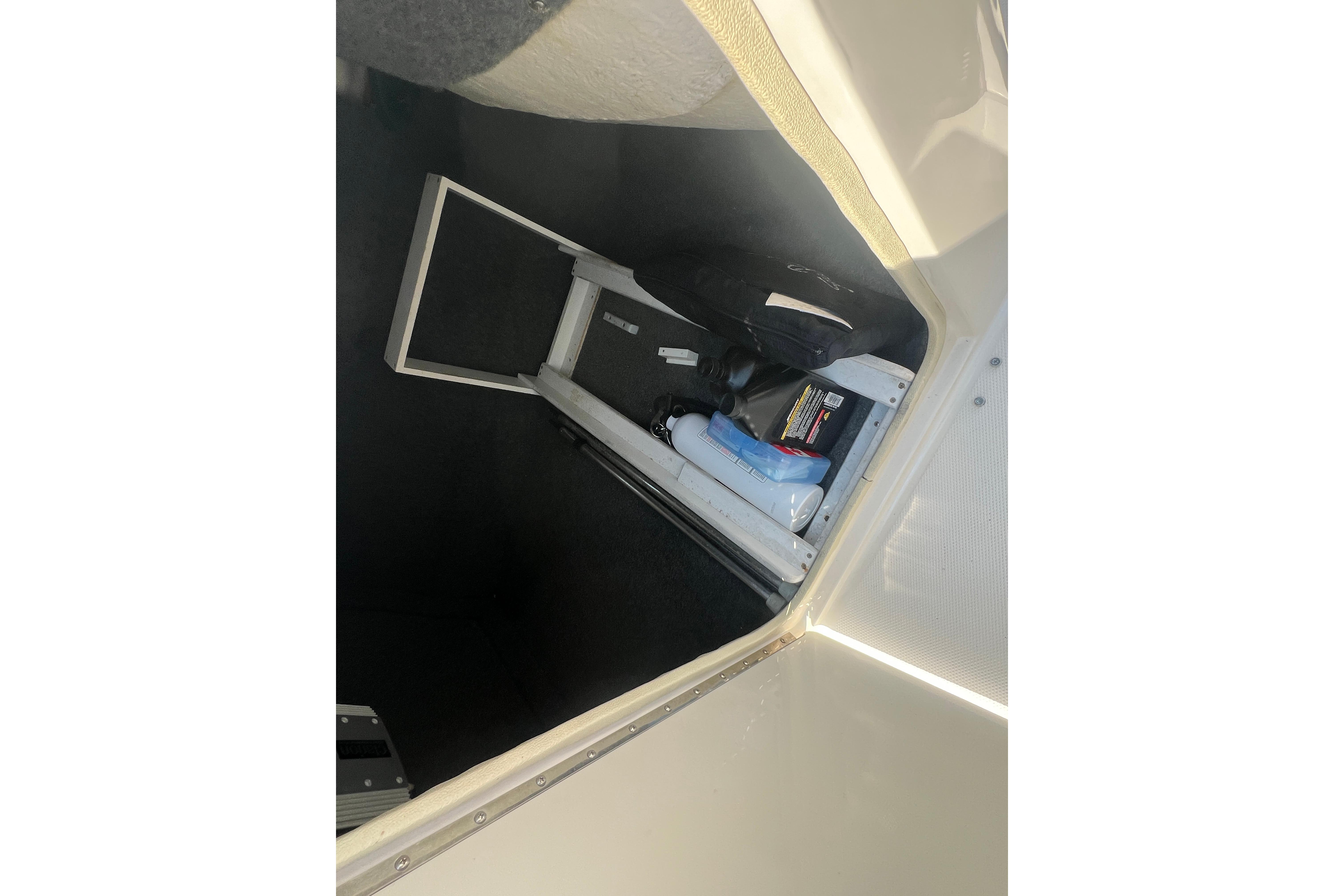 Storage compartment of a 2005 Sea Ray 240 Sundeck boat, containing various items.