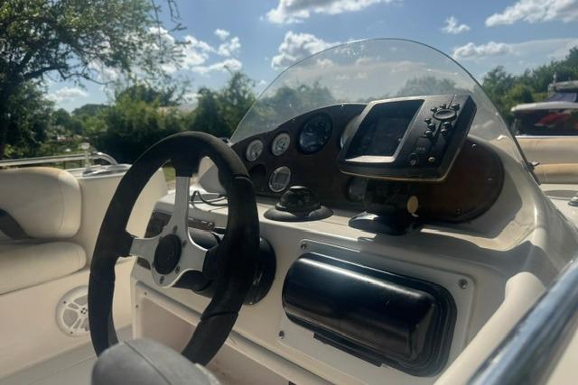 1999 Hurricane SunDeck Sport 201 OB boat dashboard with steering wheel and gauges.