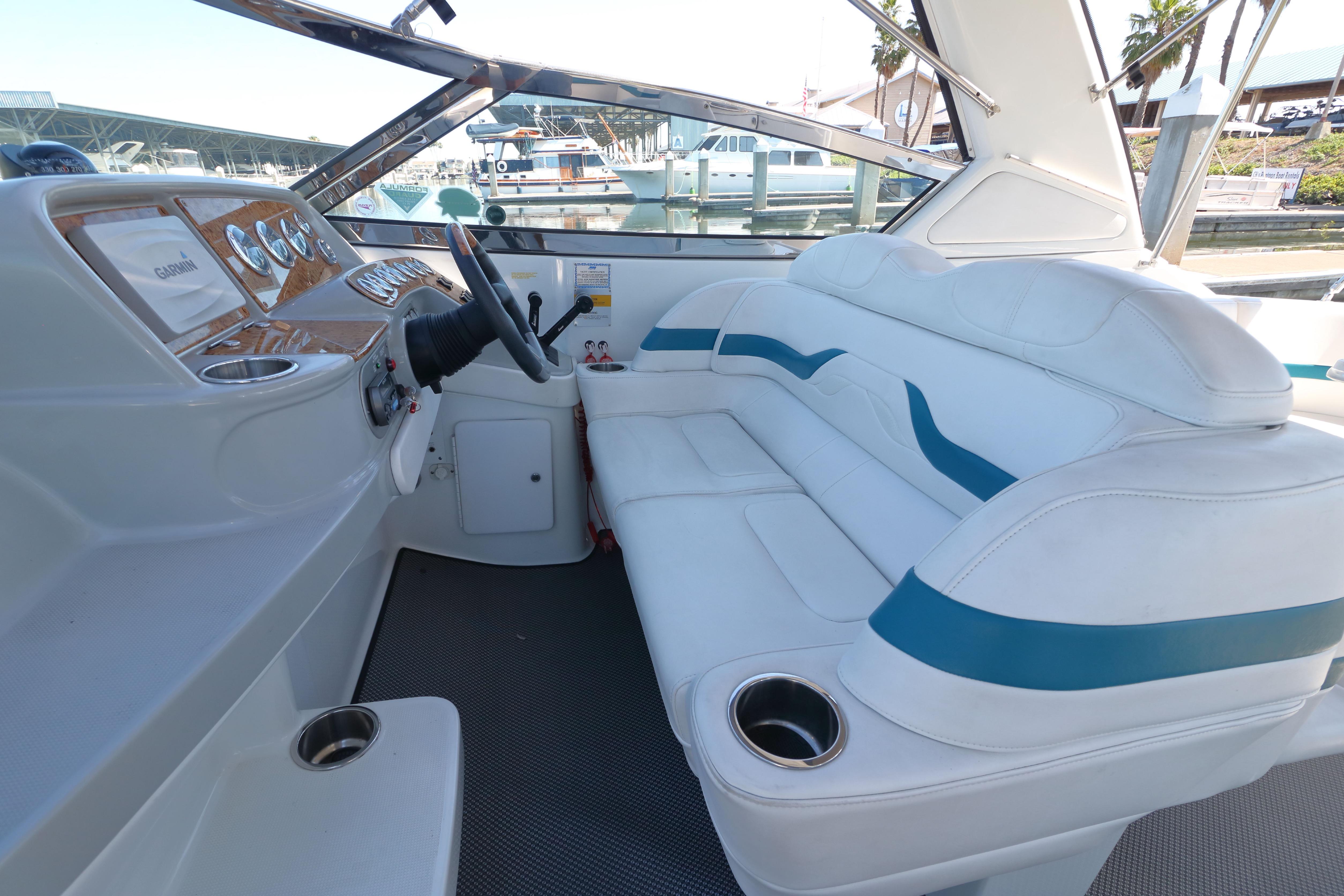2006 Formula 330 Sun Sport boat interior with white and blue seating, docked at marina.