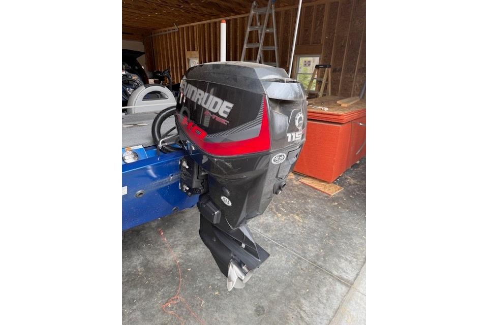 2018 Alumacraft Pro 185 with Evinrude 115 HP outboard motor in a garage setting.