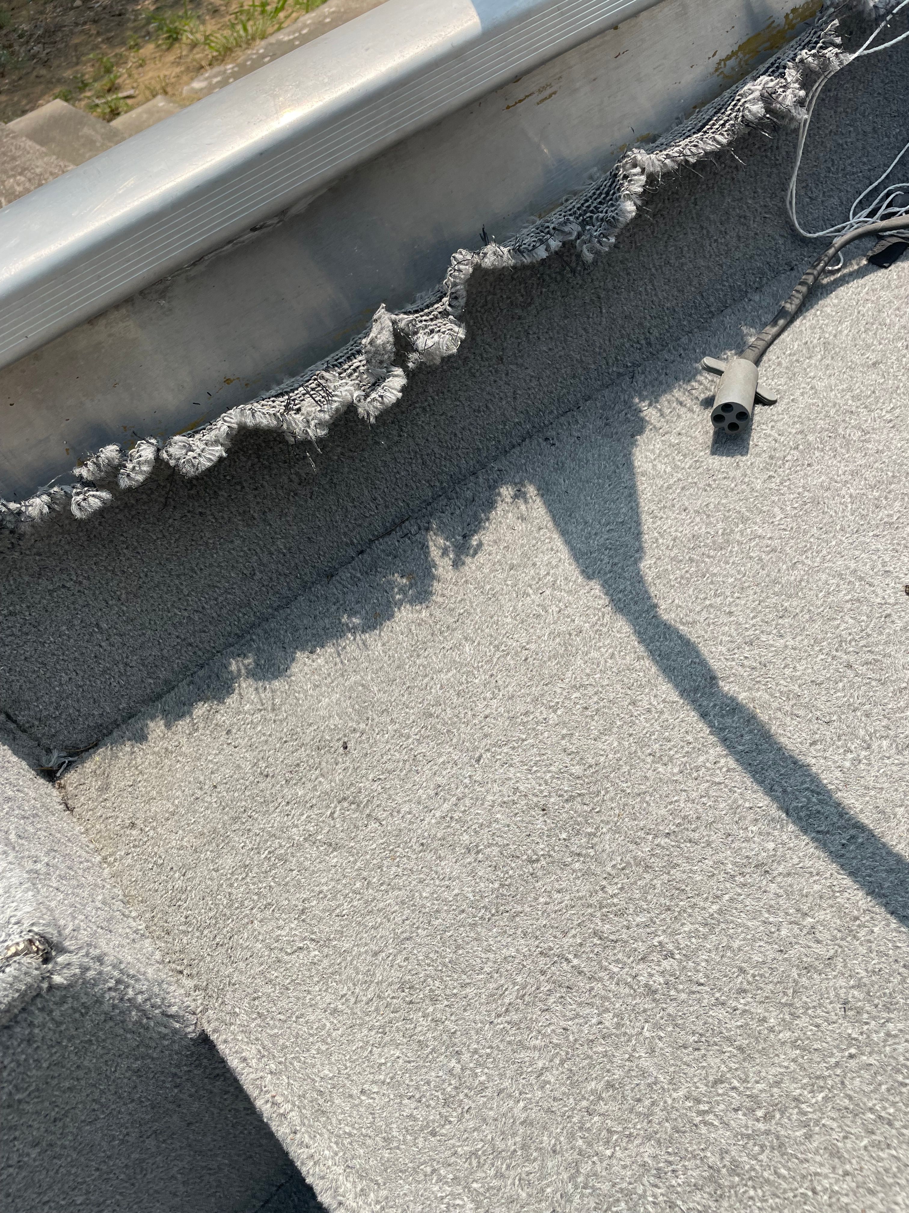 Close-up of a boat interior with worn carpet and cables.