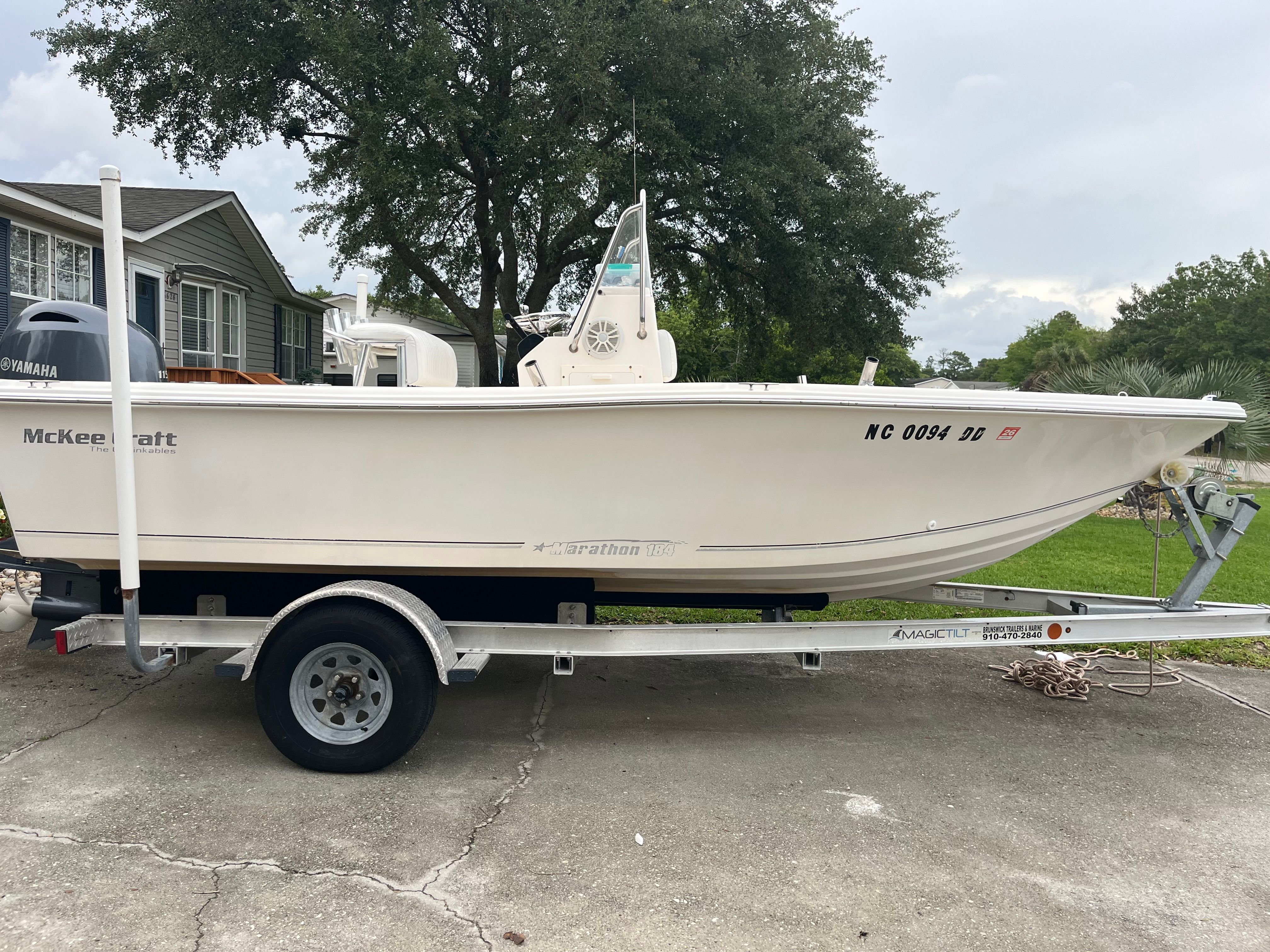 A 2005 McKee Craft Marathon 184 CC boat on a trailer, parked on a driveway.