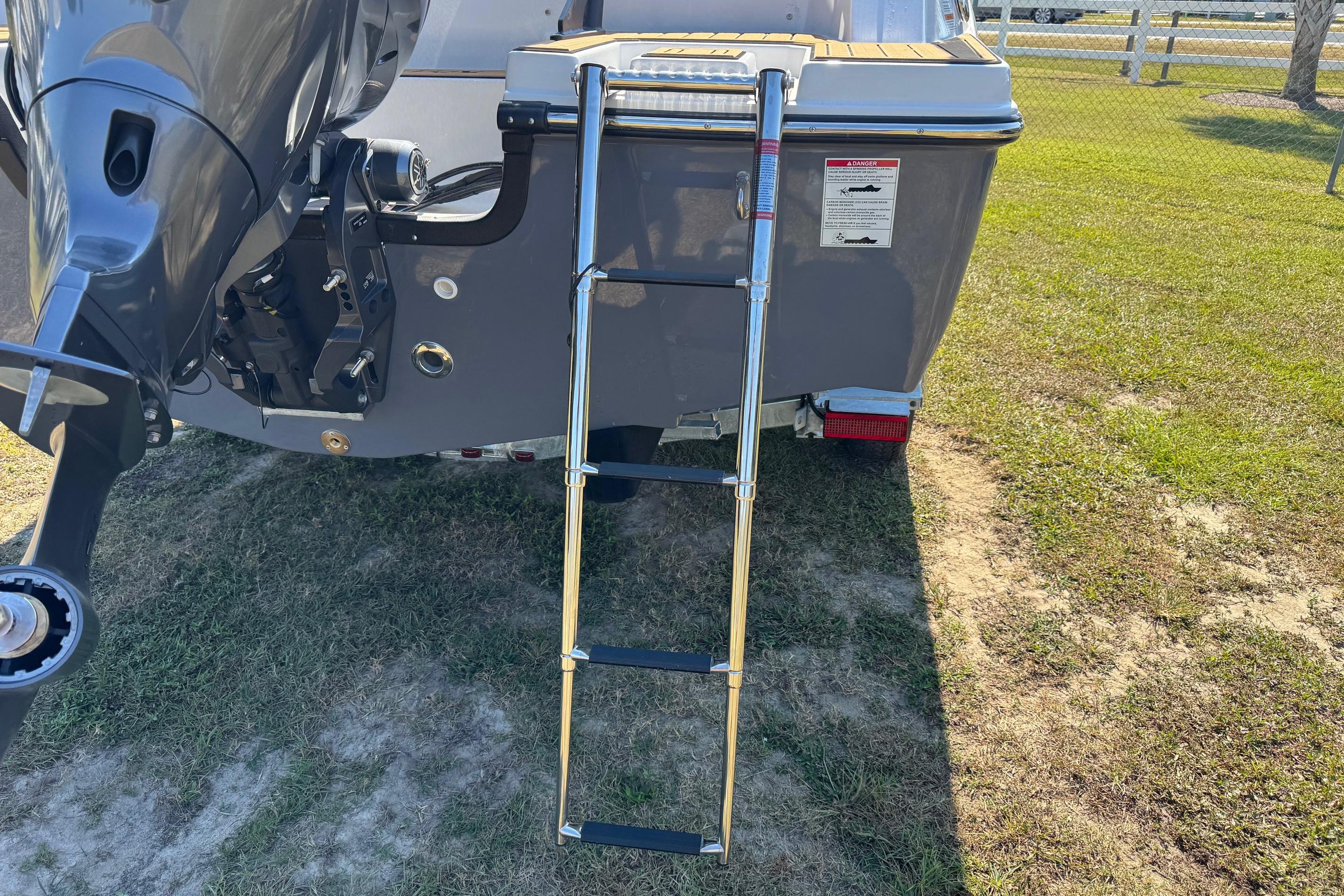Rear view of 2026 Starcraft SVX 190 OB boat with ladder and outboard motor.