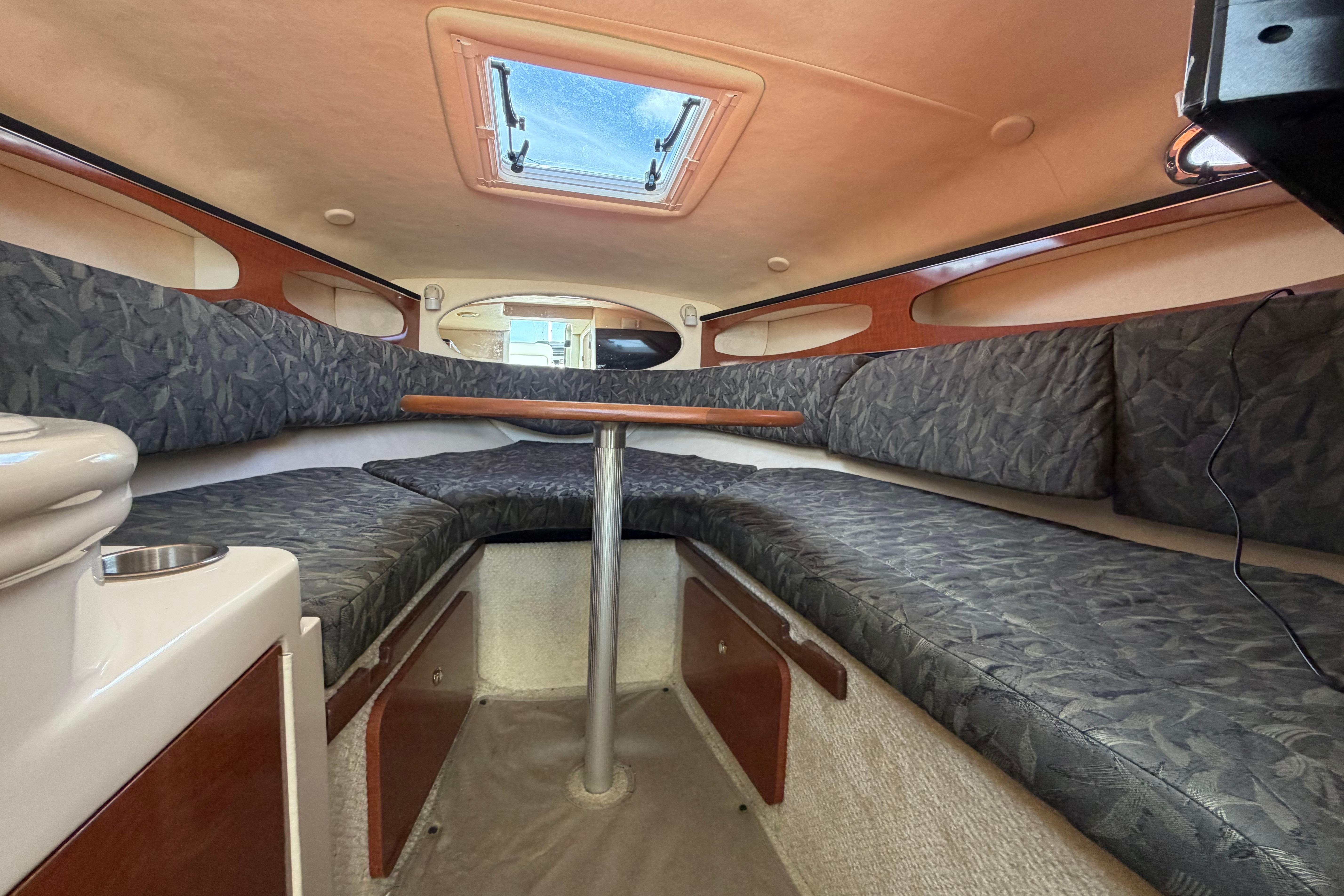 Interior cabin of 2004 Sea Ray Sundancer 260 with cushioned seating and overhead hatch.